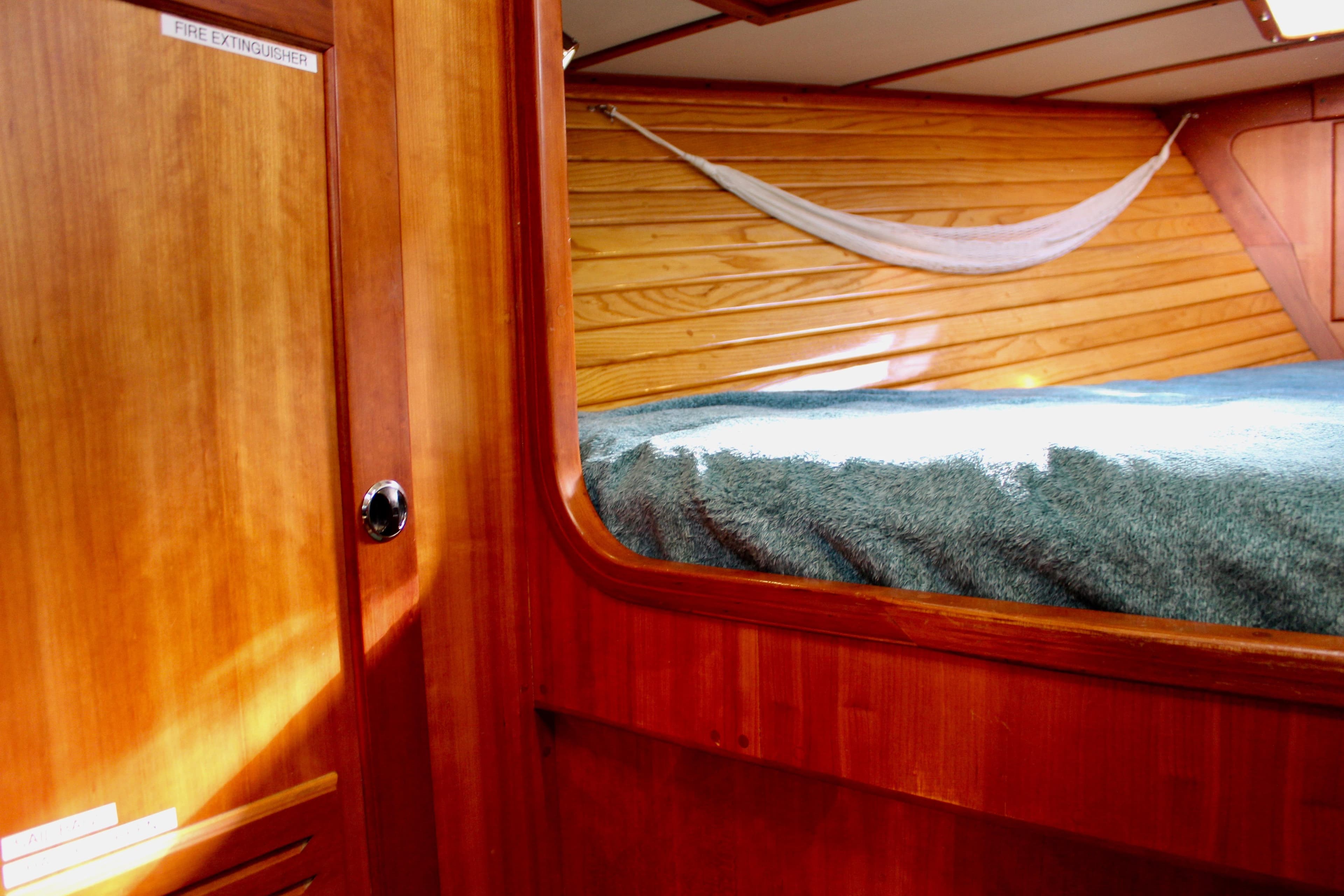 Interior of 1997 Valiant 39 sailboat with wooden paneling and cozy sleeping area.