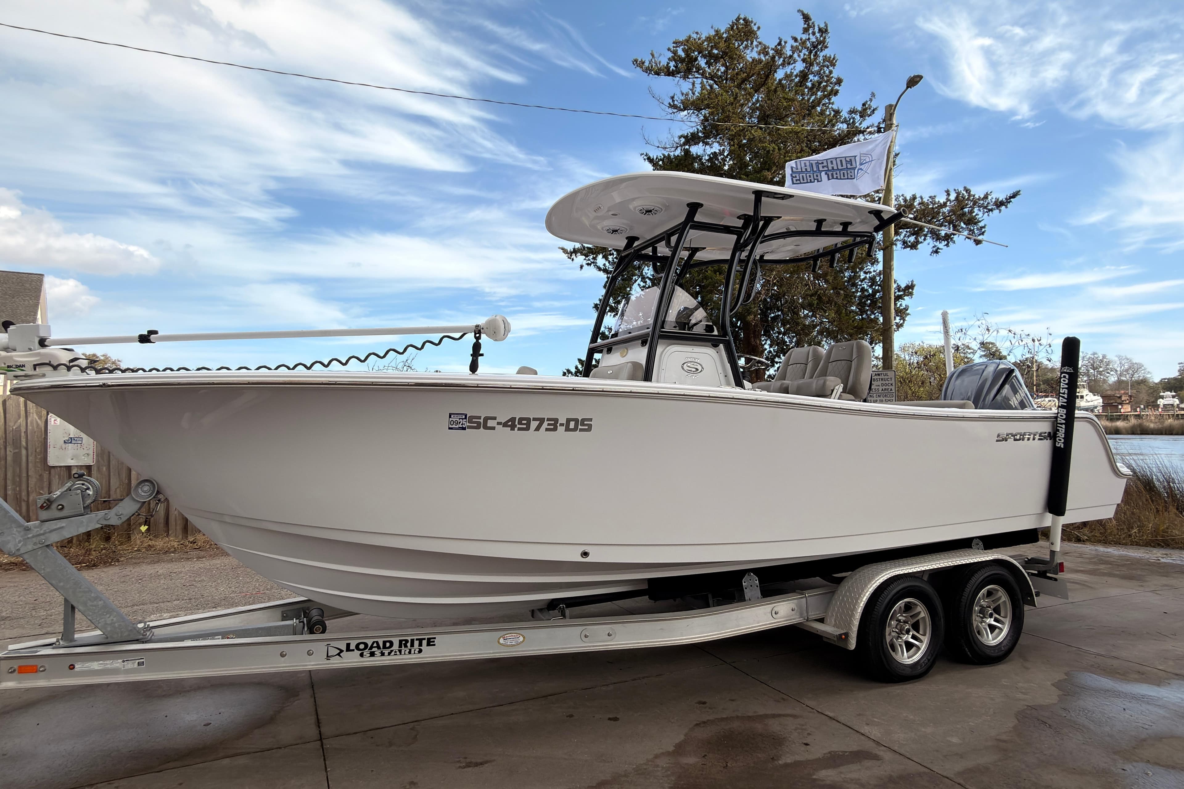 2022 Sportsman Open 242 Center Console boat on trailer, parked outdoors.
