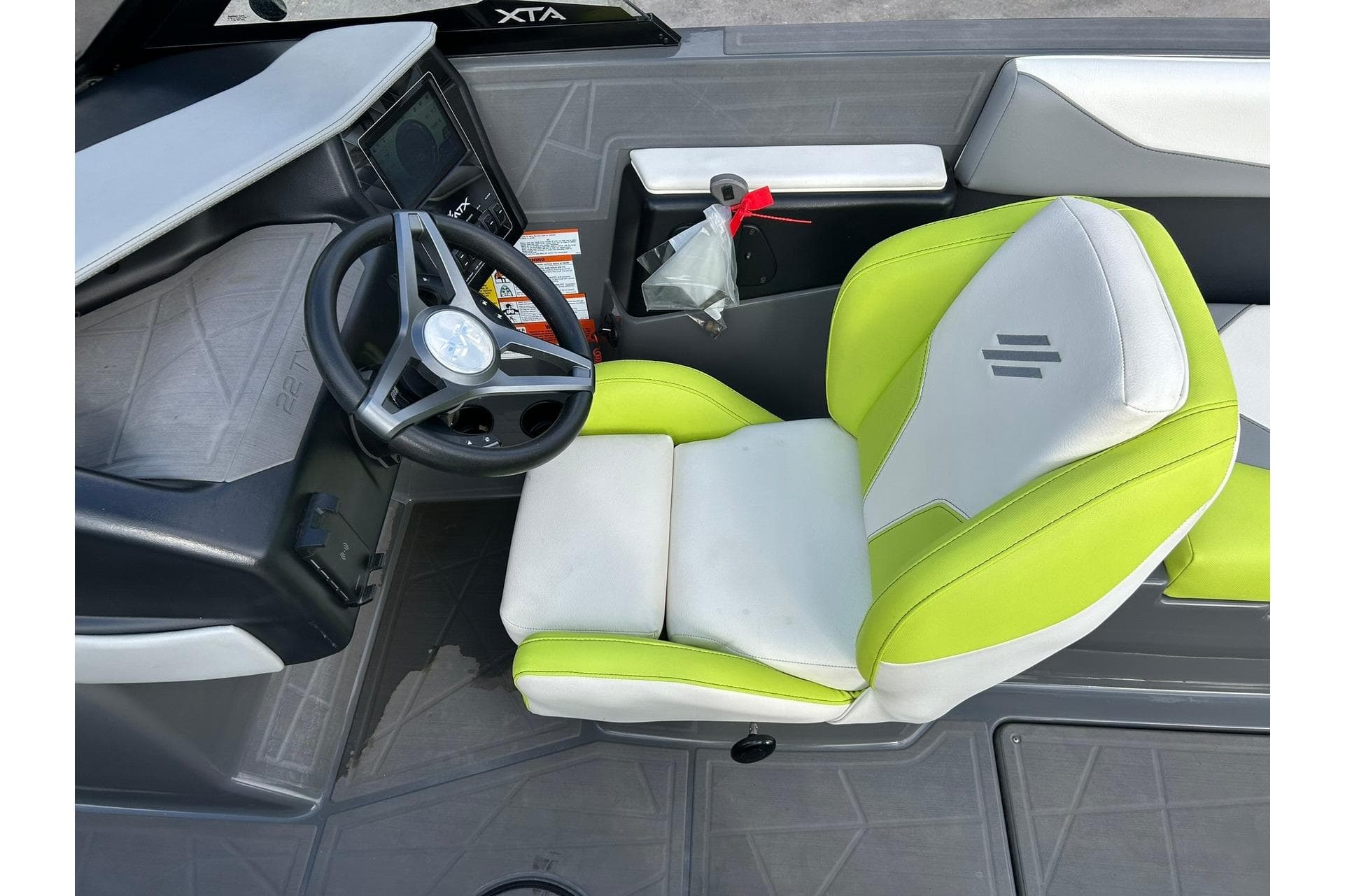 ATX 22 Type-S 2021 boat interior with lime green and white seating, steering wheel, and dashboard.