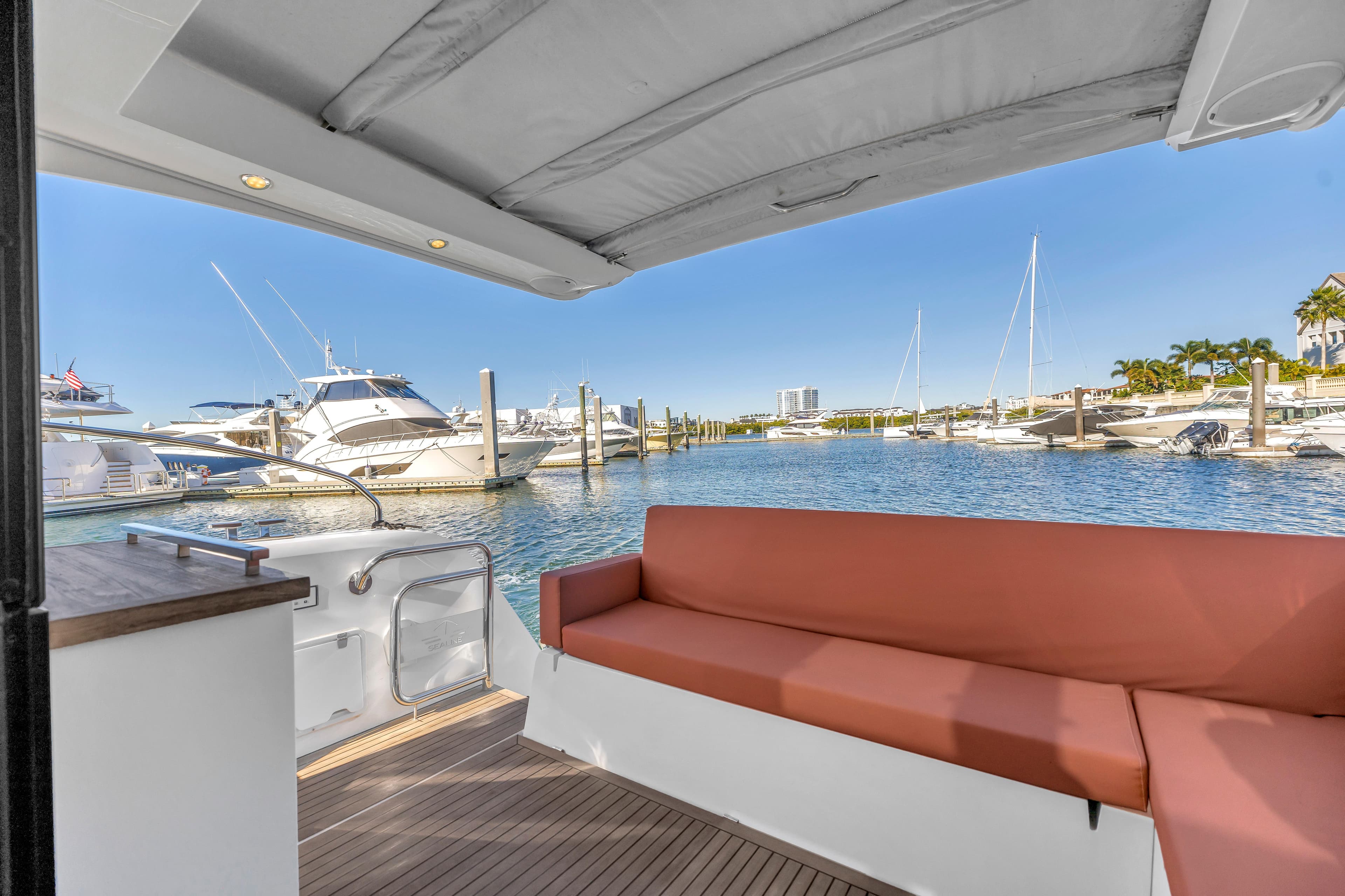 2020 Sealine C390 yacht interior with marina view, featuring a comfortable seating area.
