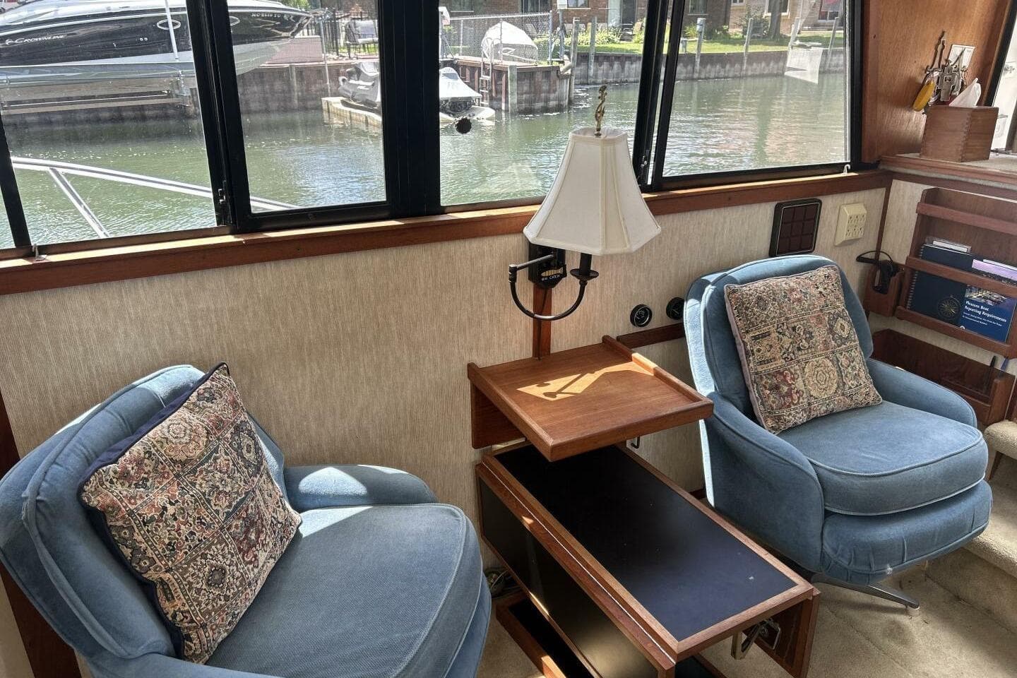 Interior of 1985 Carver 3207 Aft Cabin with blue chairs and decorative pillows.