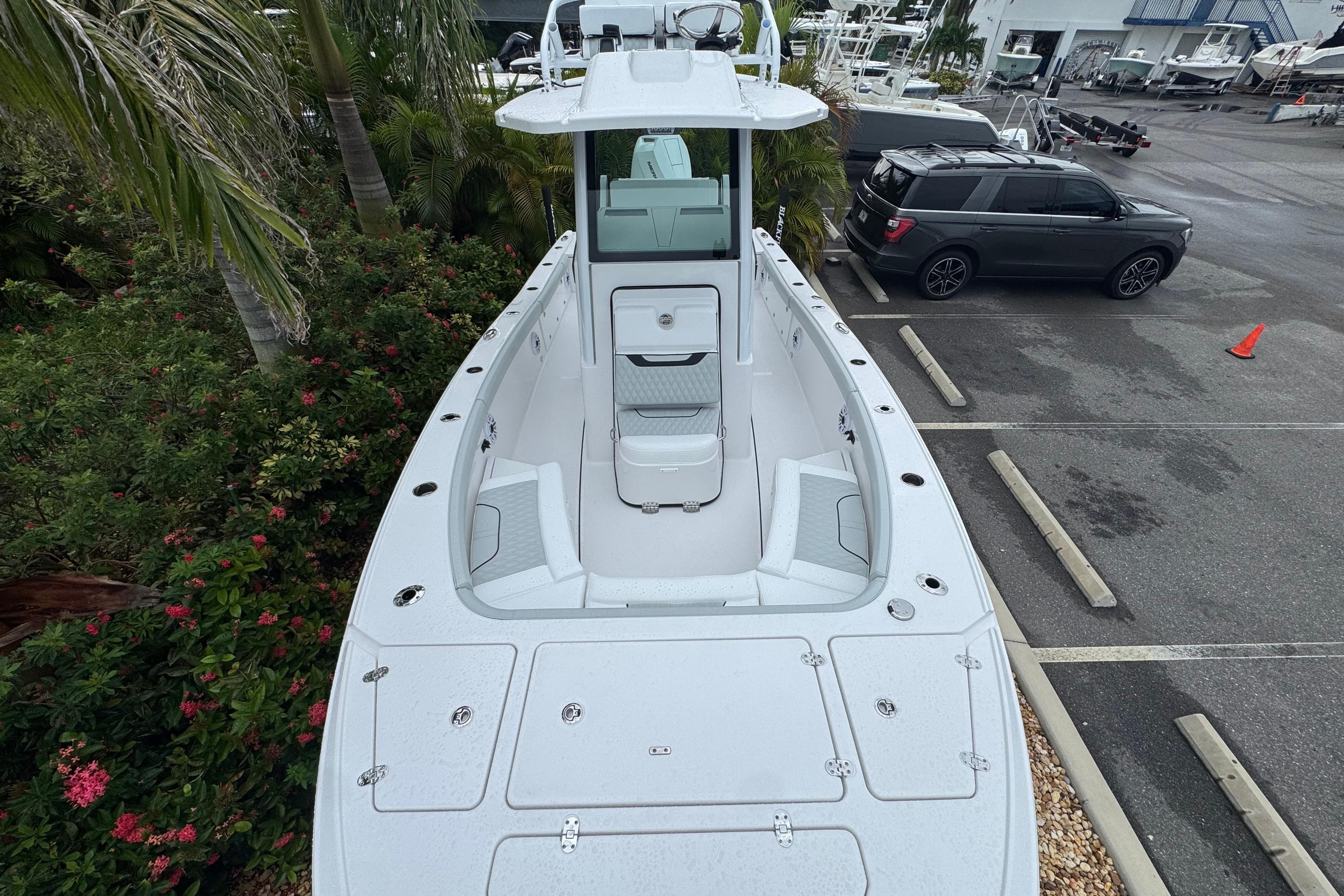 2026 Blackfin 262 HB boat in parking lot, surrounded by greenery and vehicles.