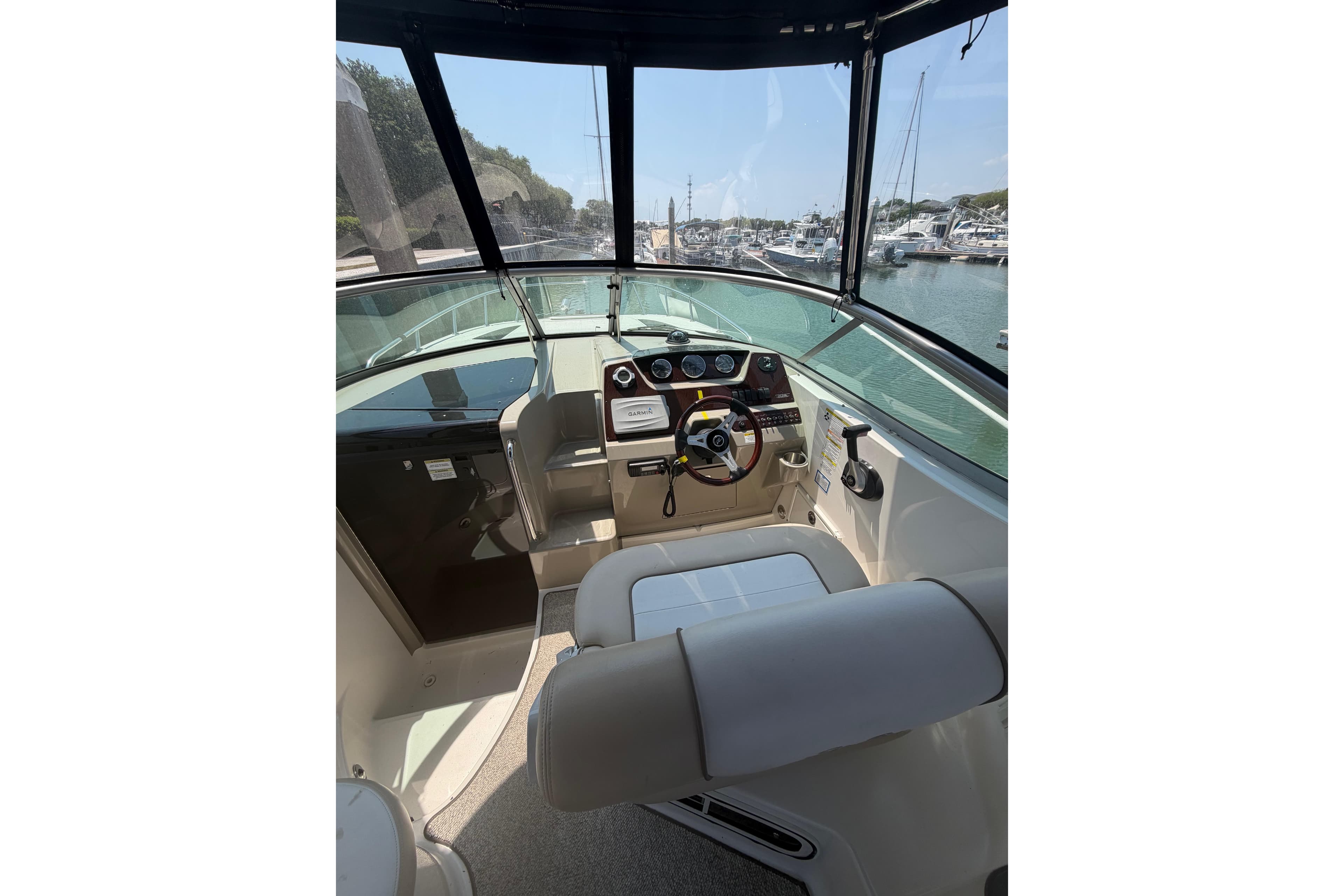 Interior view of 2013 Sea Ray Sundancer 260 boat cockpit with steering wheel and controls.