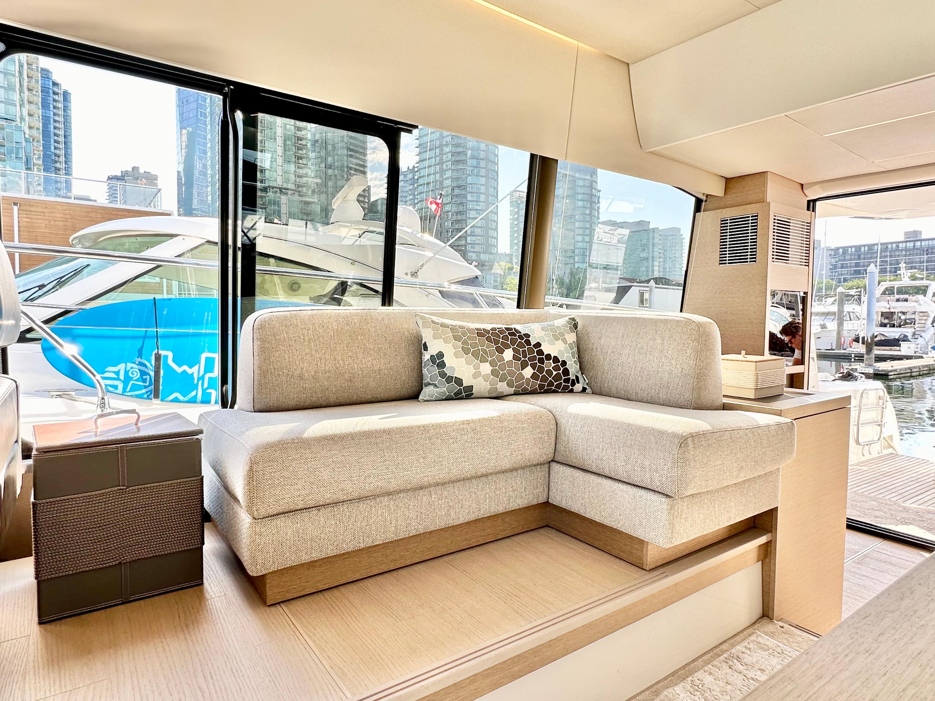 Luxurious interior of 2023 Prestige 520 yacht with modern sofa and marina view.