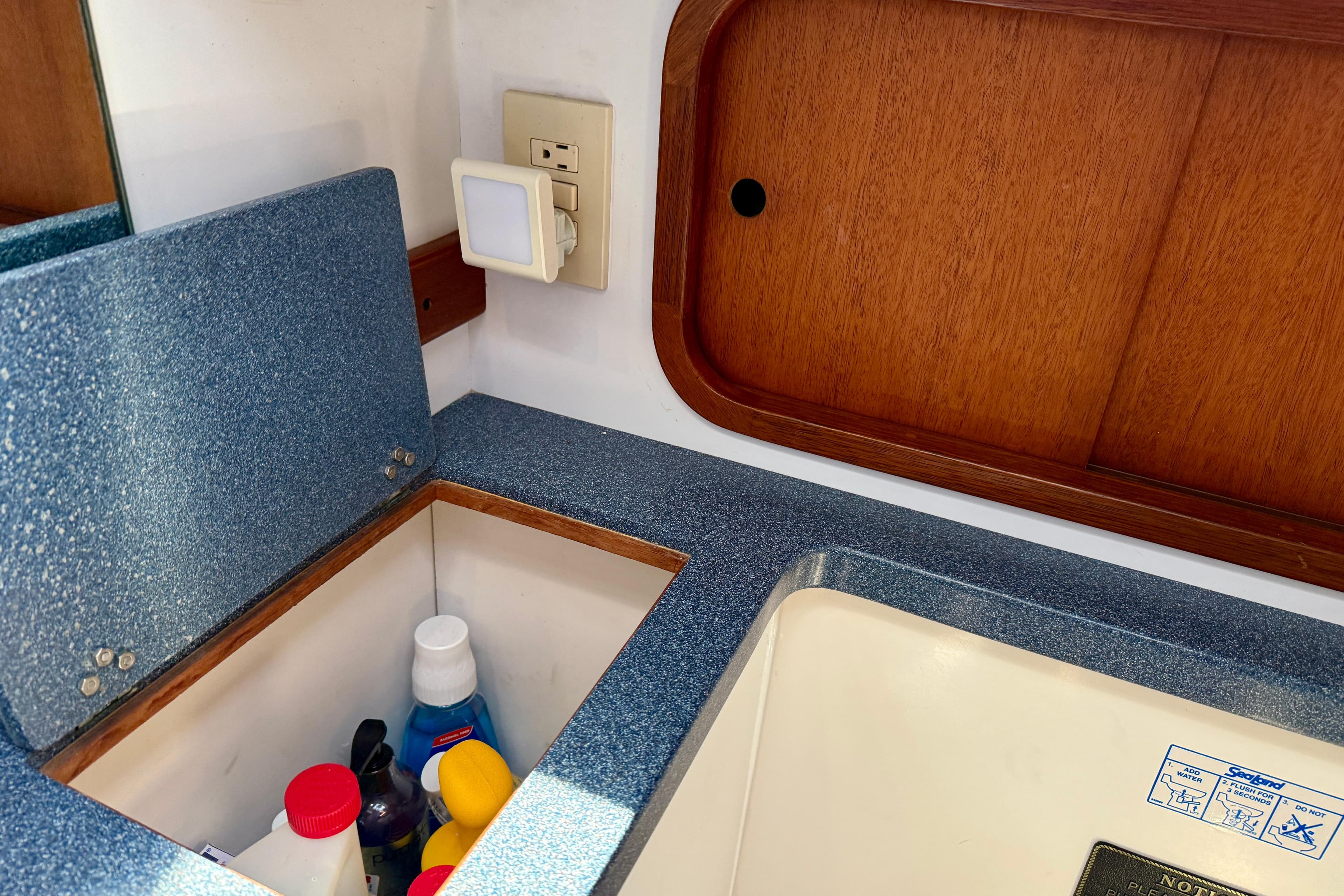 Interior of 1999 Legacy 40 boat with storage compartment and wooden paneling.