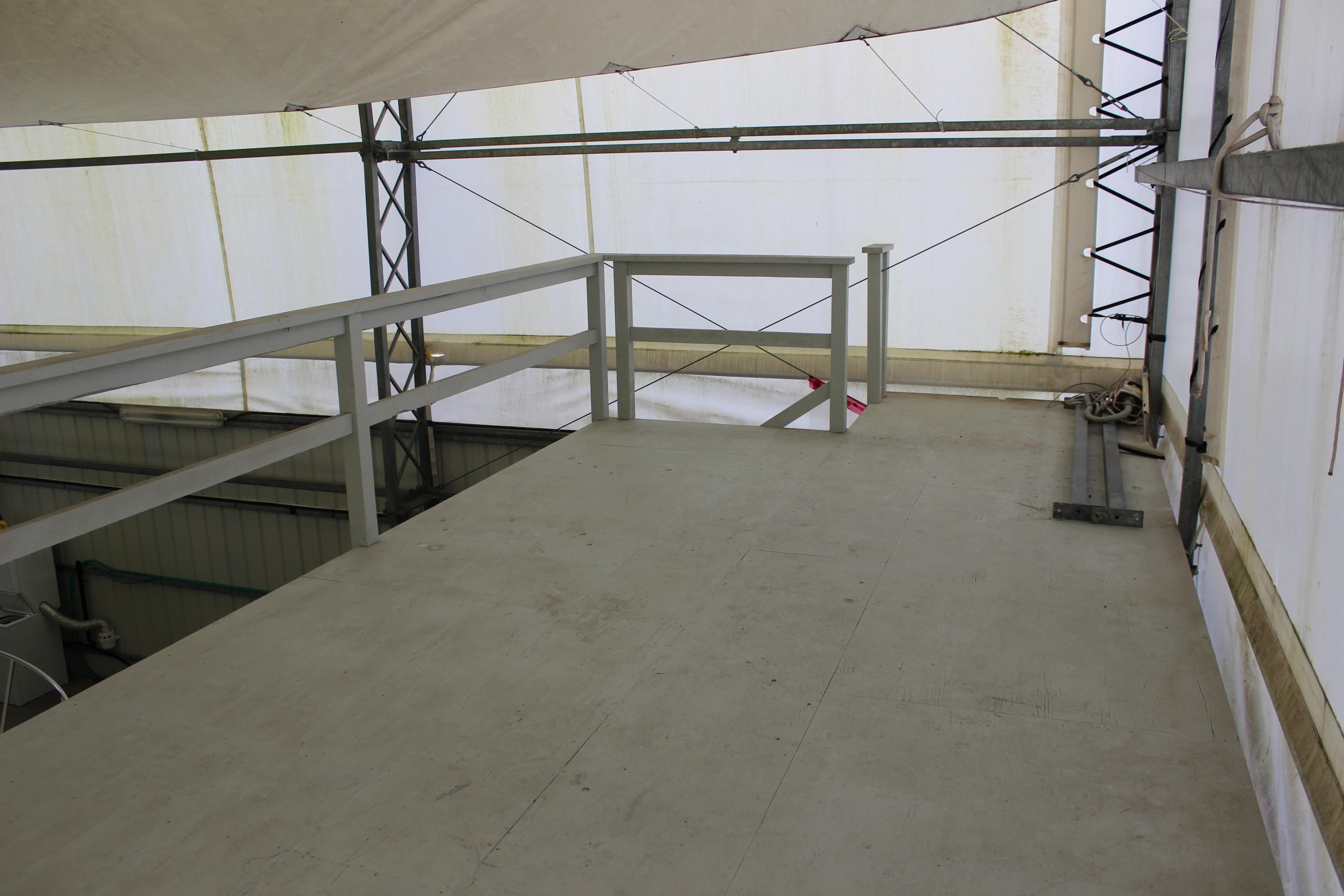 Elevated platform inside a 2005 custom boathouse with metal railings and structural beams.