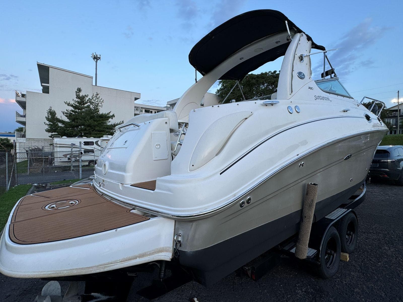 2006 Sea Ray 280 Sundancer boat on trailer, white exterior, docked outdoors.