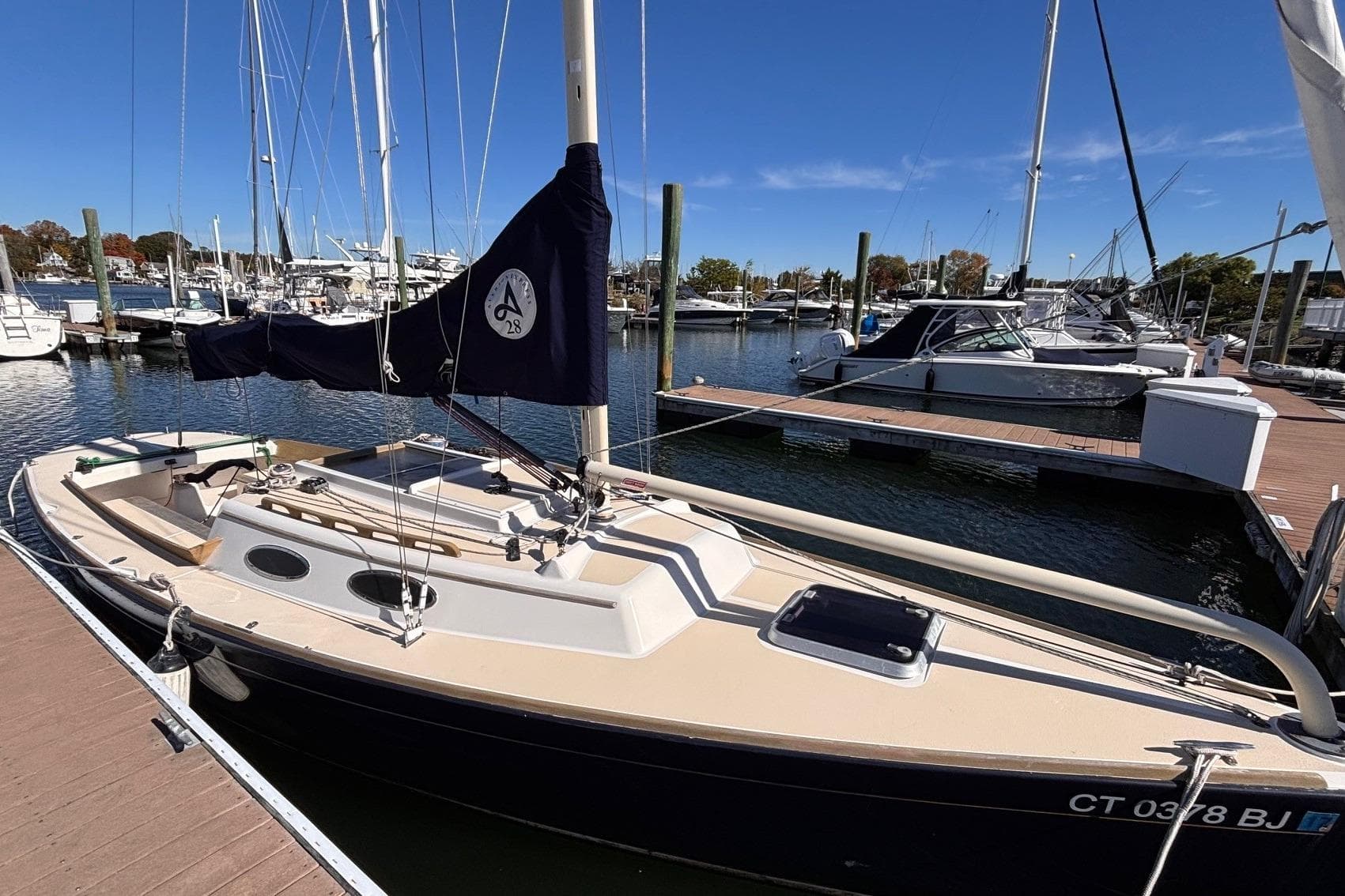 2016 Alerion Express 28 sailboat docked at a marina under clear blue skies.