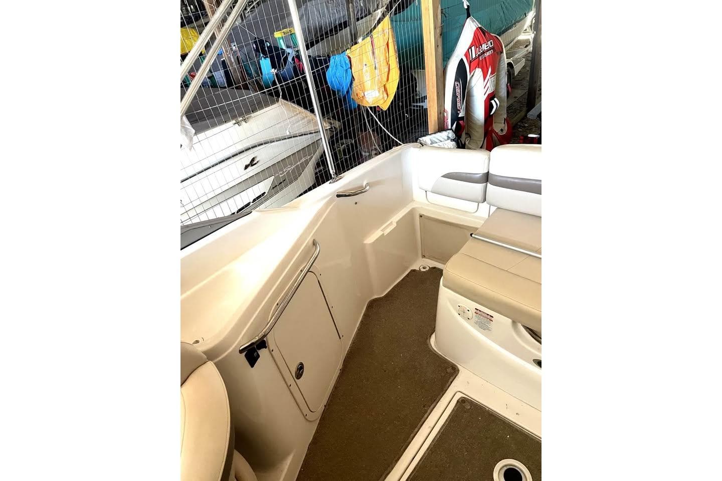 2007 Chaparral 215 SSi boat interior with beige seating and storage compartments.
