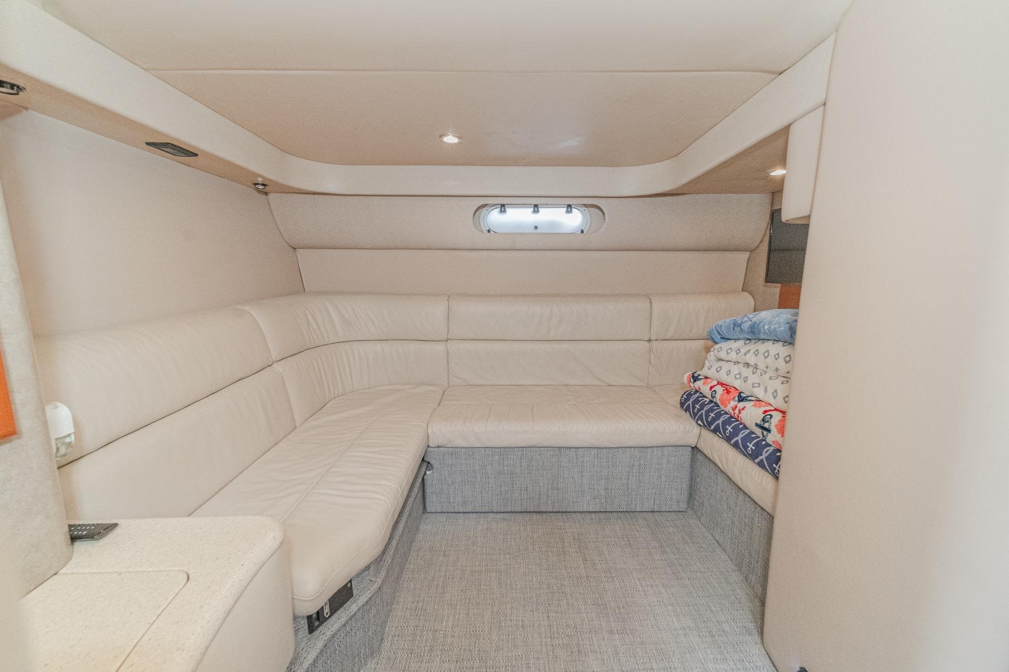 Interior of 2005 Formula 40 Performance Cruiser with beige seating and stacked blankets.