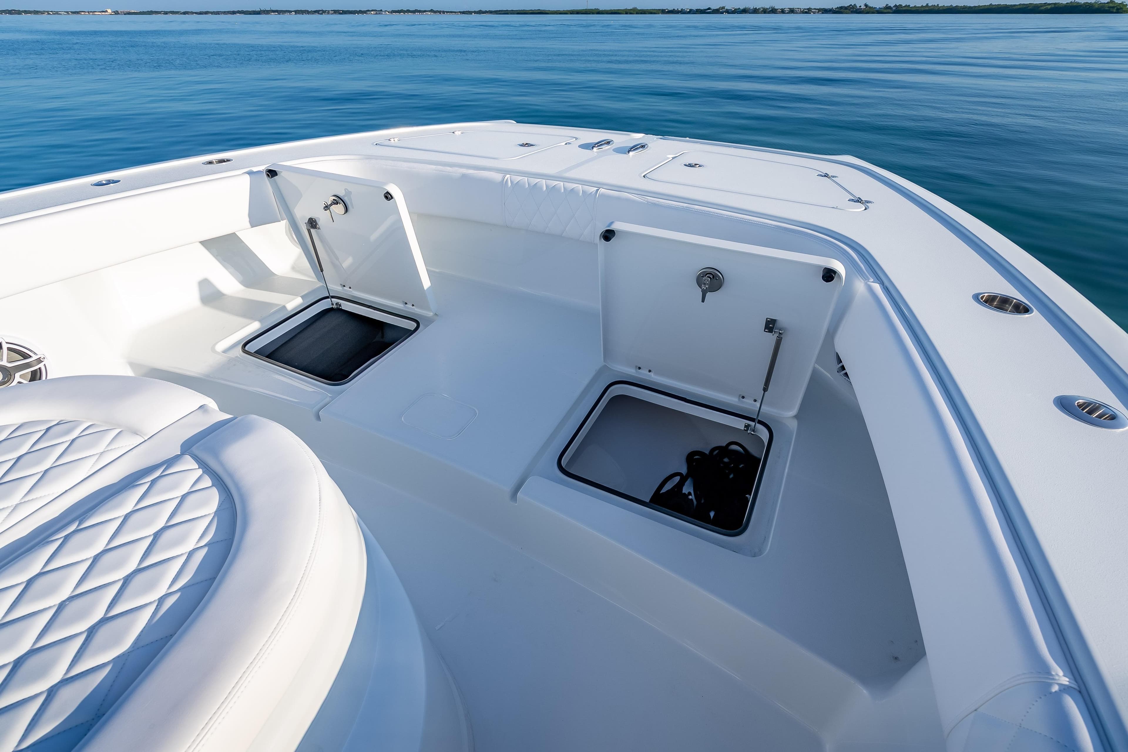 2026 Freeman 35 boat deck with open storage compartments on calm water.