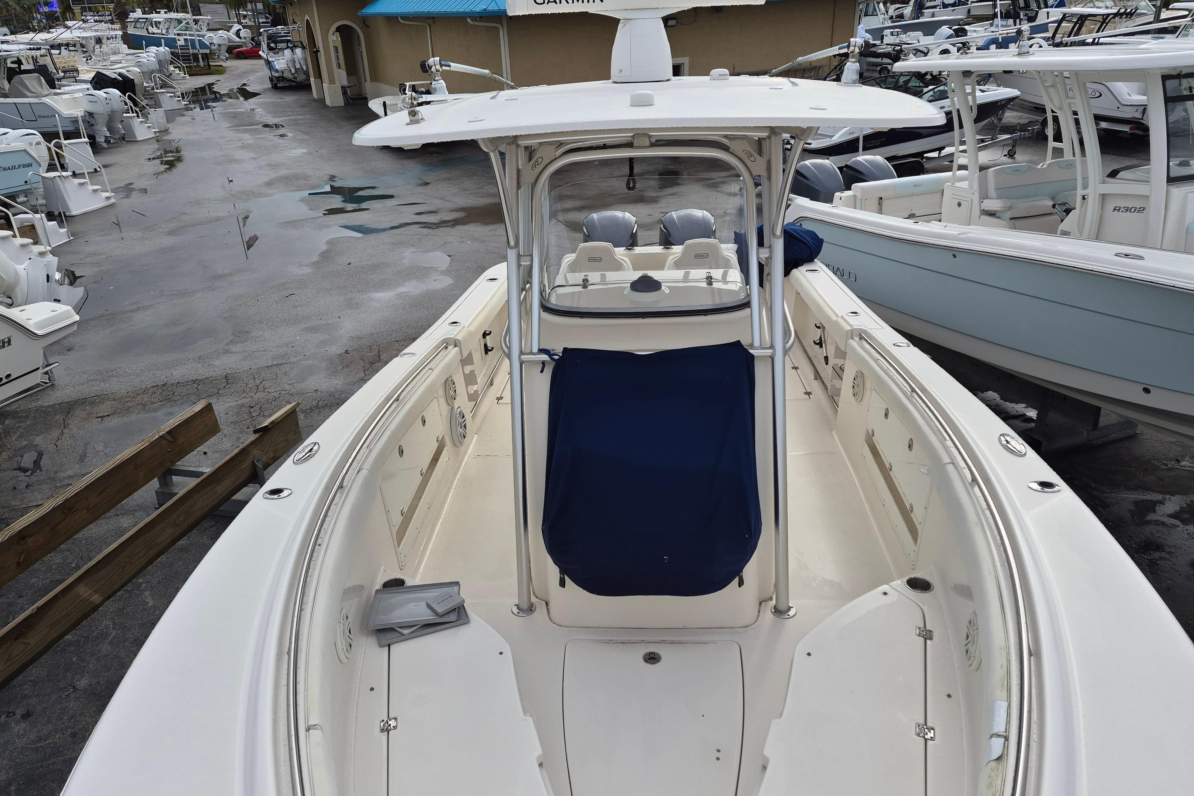 2014 Robalo R300 Center Console boat in marina, showcasing spacious deck and helm.