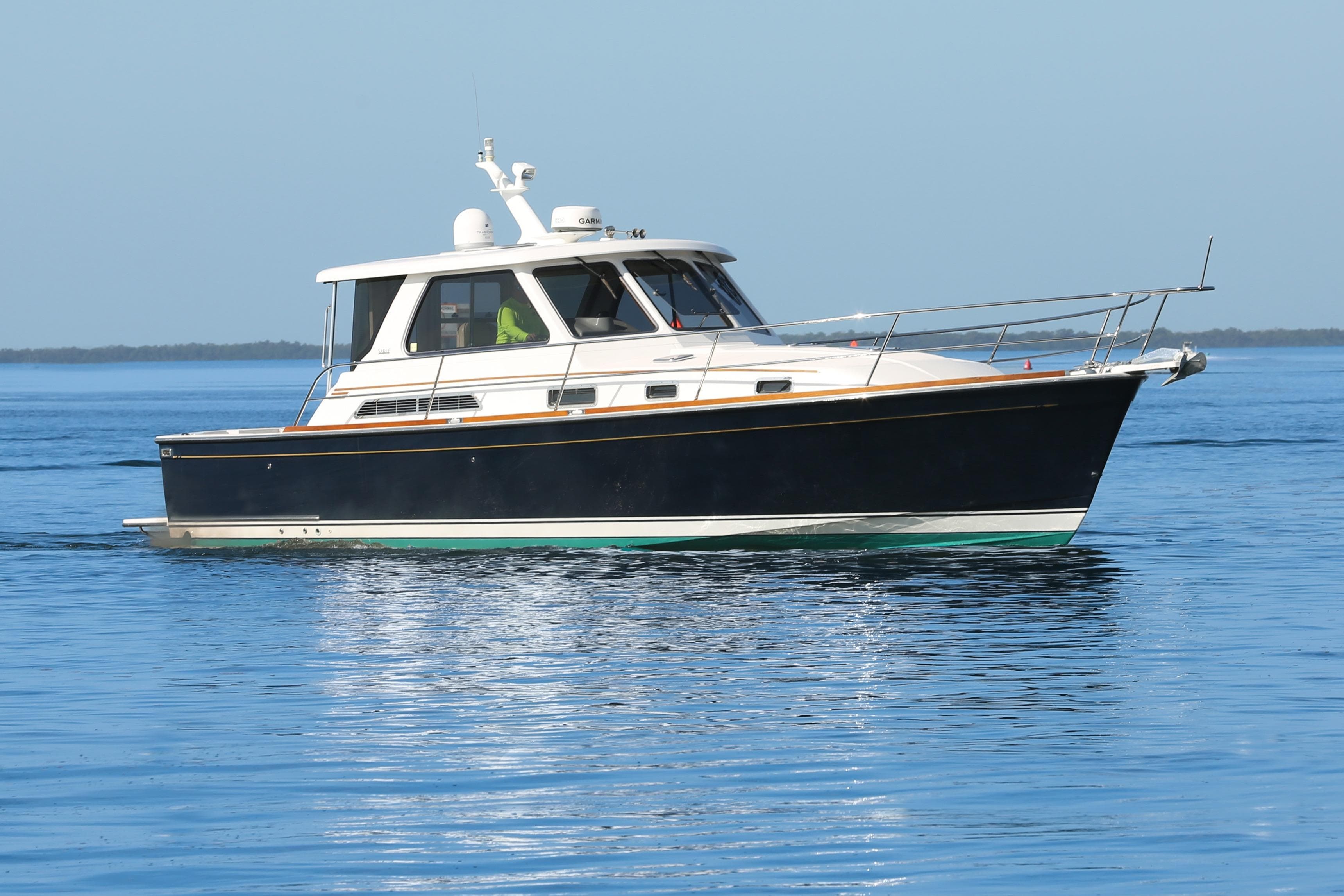 2006 Sabre 38 Hard Top Express yacht cruising on calm blue waters.