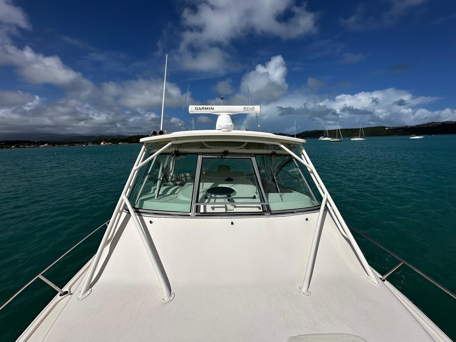 2016 Grady-White Express 370 boat on turquoise water under a partly cloudy sky.