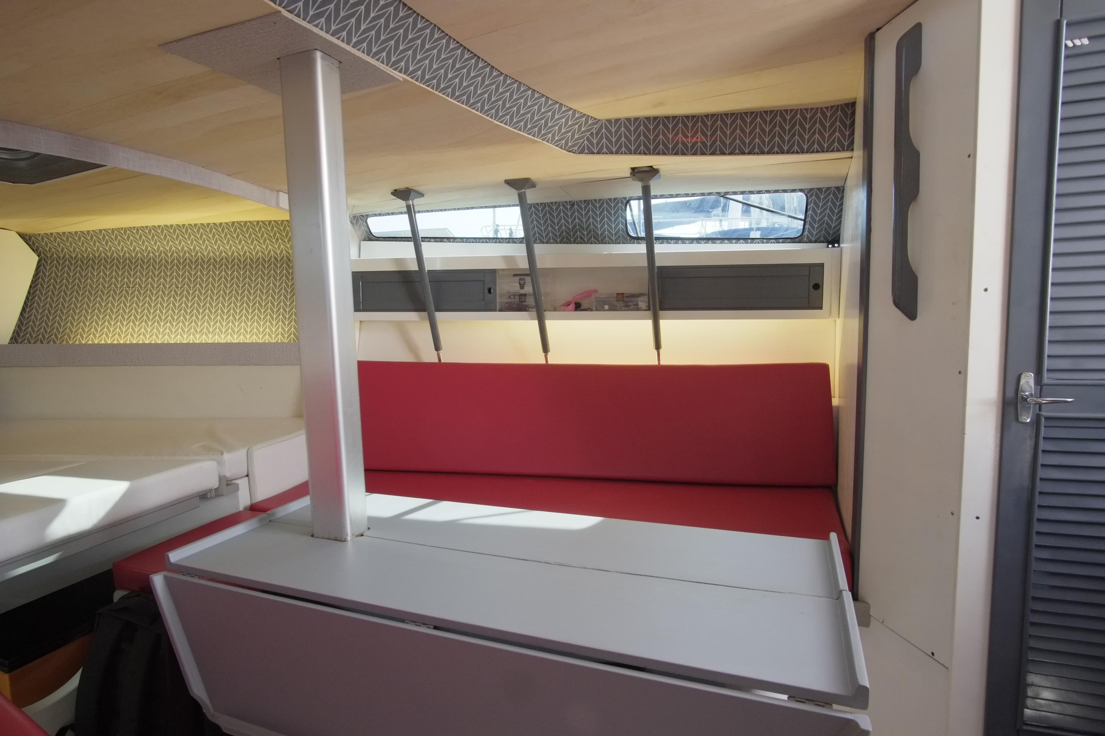 Interior of 1983 Maxi 100 PS sailboat with red seating and modern design elements.