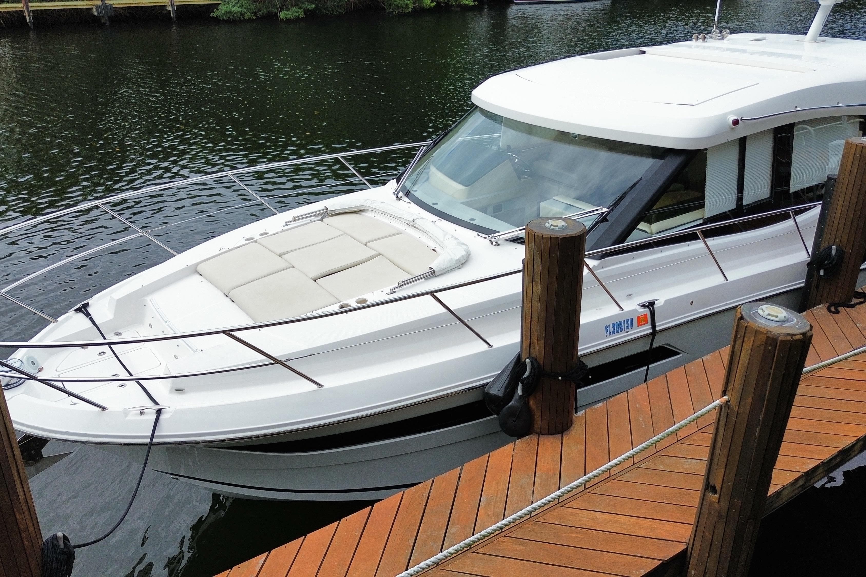 2021 Regal 38 XO boat docked on a wooden pier by the water.