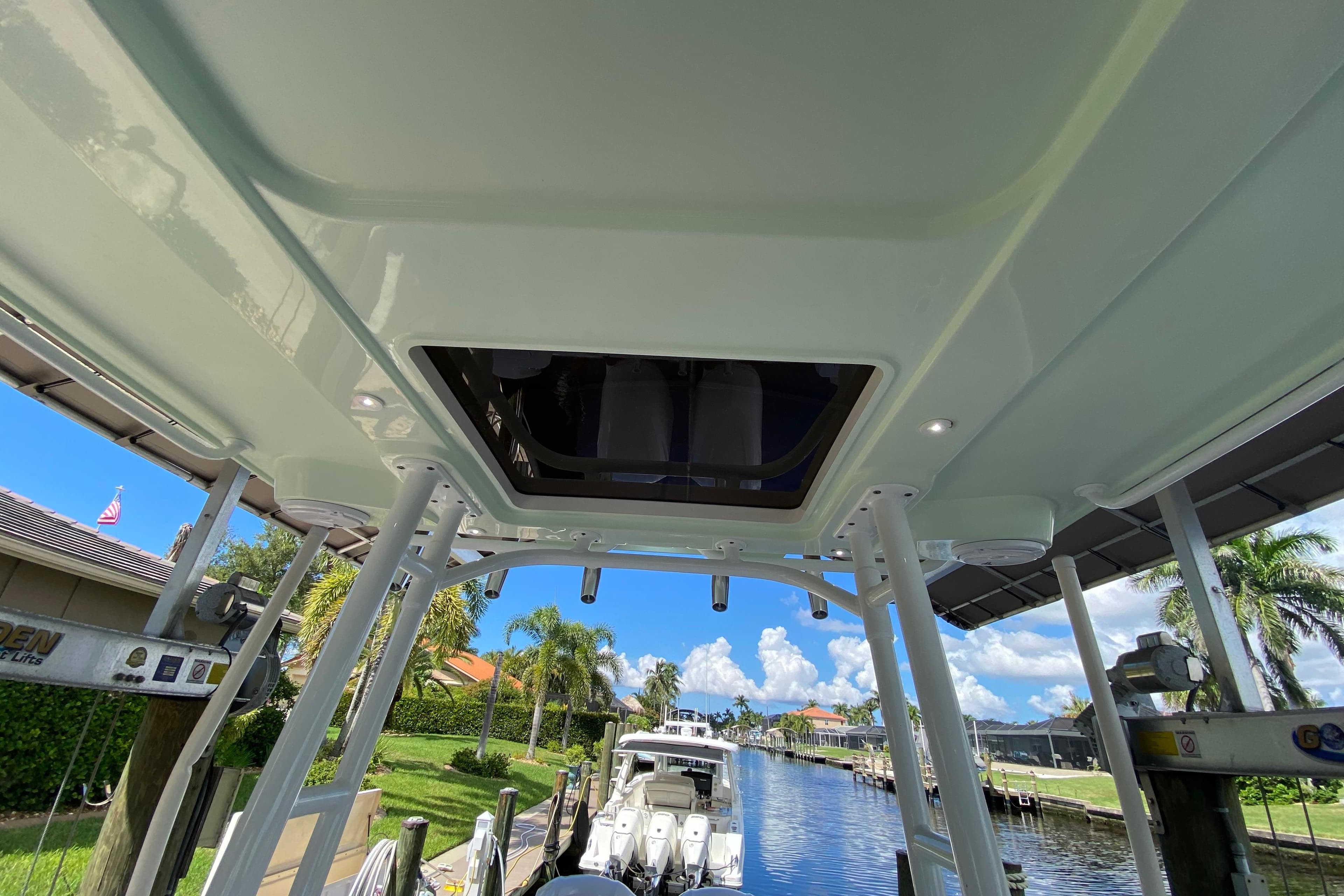 2015 Edgewater 320CC boat interior view with canal and palm trees in background.