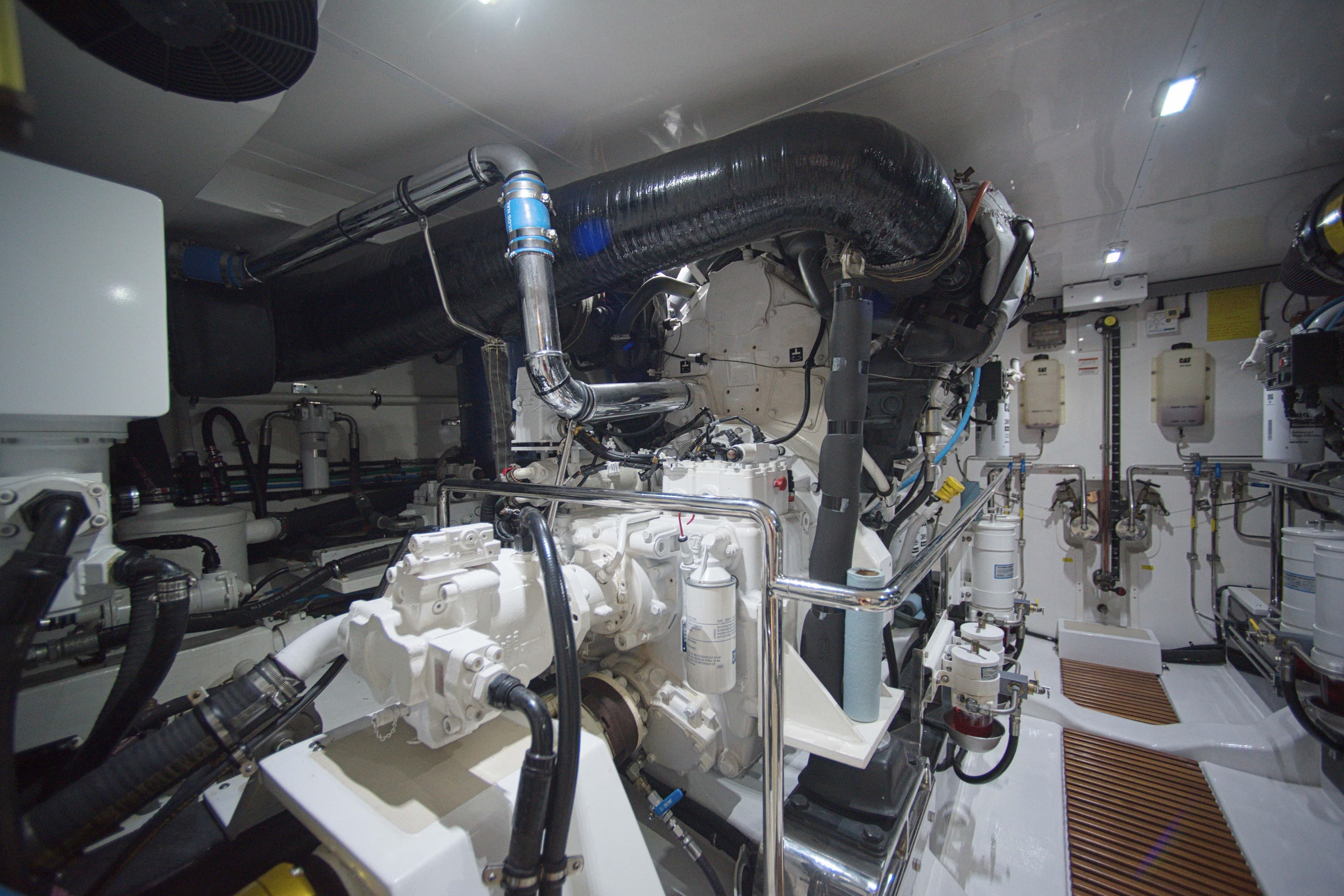 Engine room of 2018 Marlow 75E-CB yacht, showcasing complex machinery and piping.