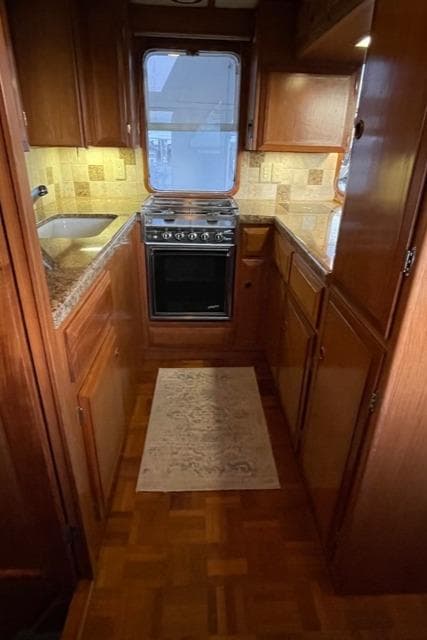 1994 DeFever Double Cabin kitchen with wood cabinetry, stove, and sink.
