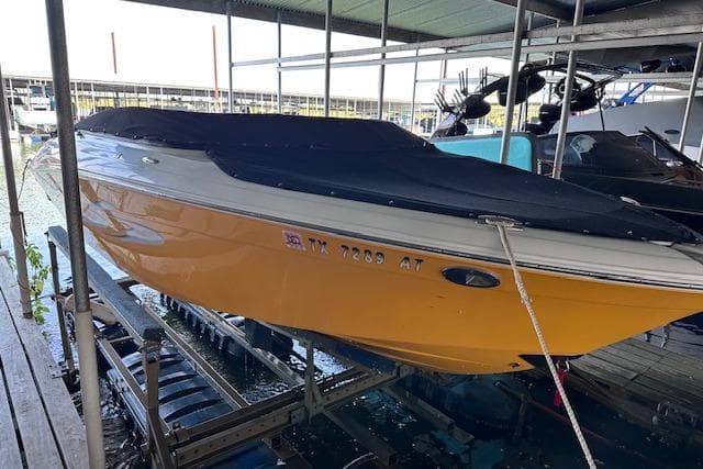 2004 Four Winns 210 Horizon SS boat with black cover, docked in a marina.