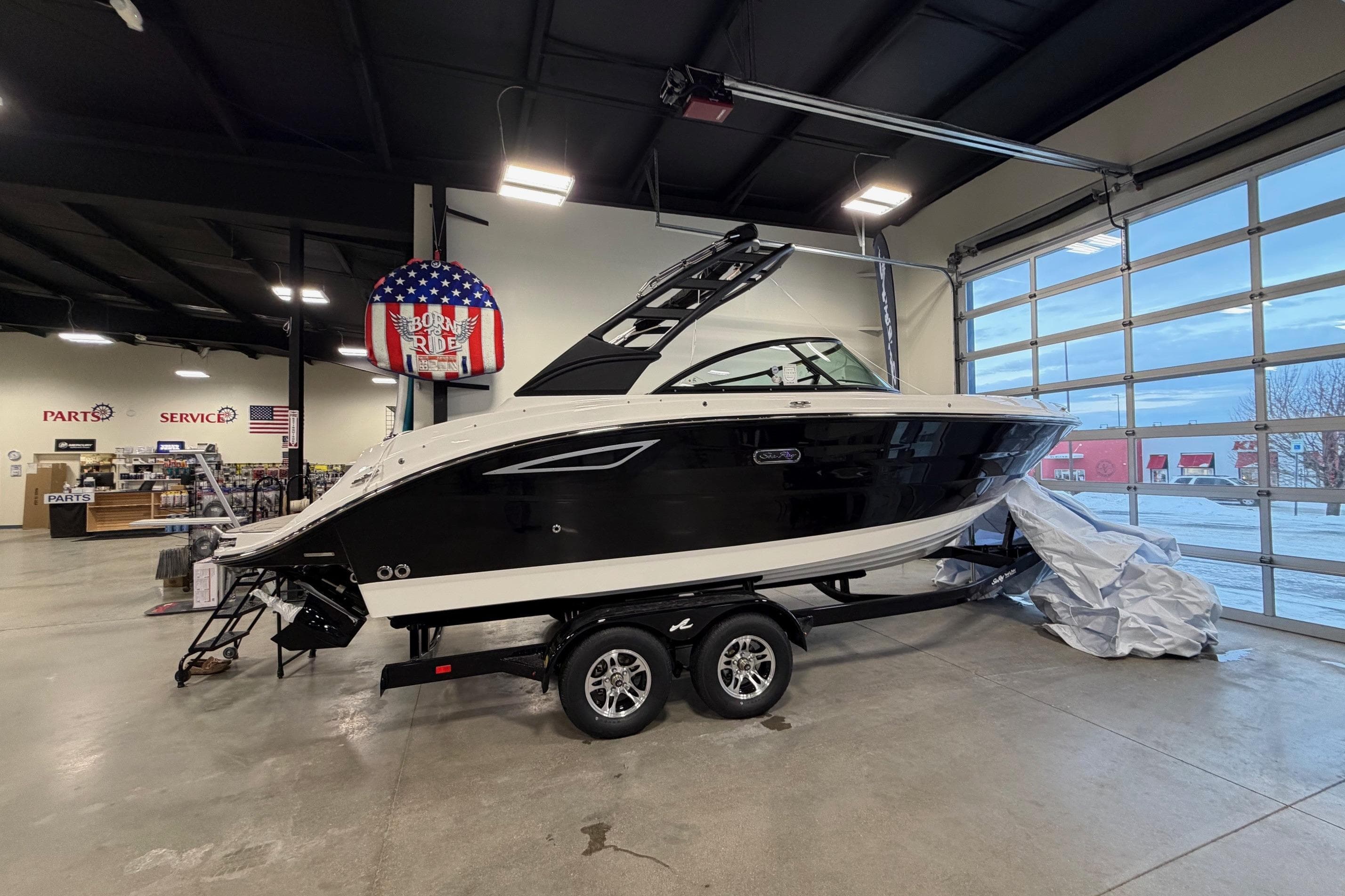 2026 Sea Ray SDX 230 boat displayed indoors on a trailer.
