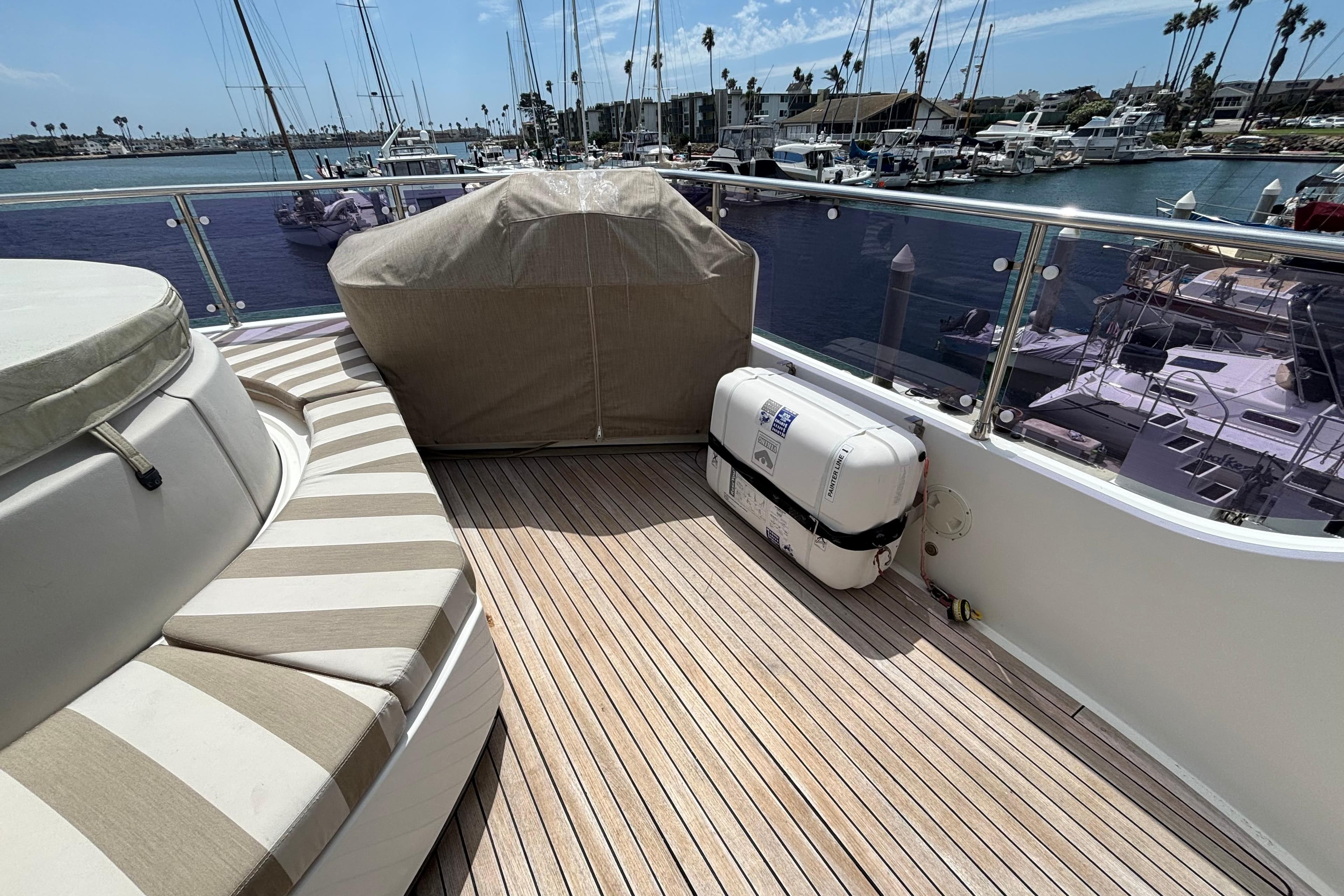 Deck of 2010 Norseman 80 yacht with striped seating and marina view.