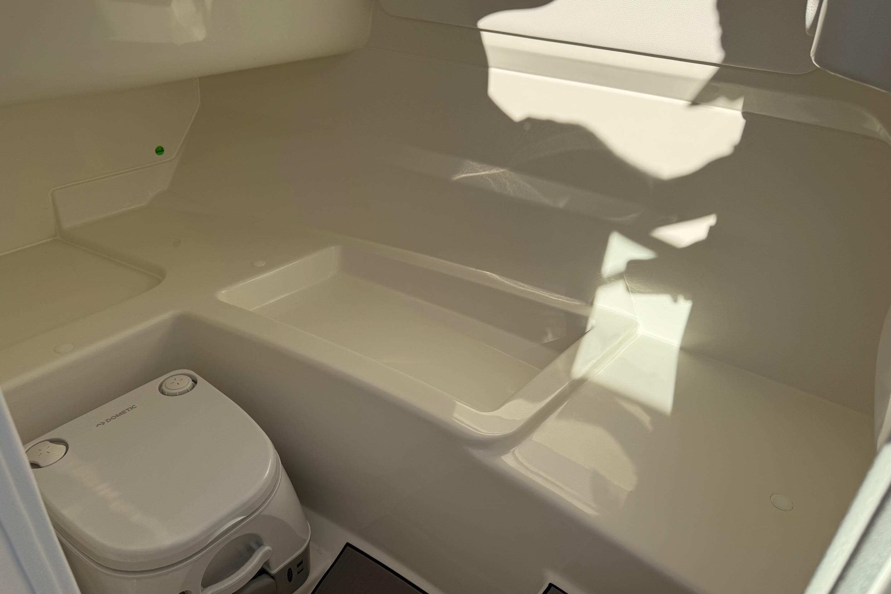 Interior of 2026 Sea Ray SDX 230 boat with compact toilet.