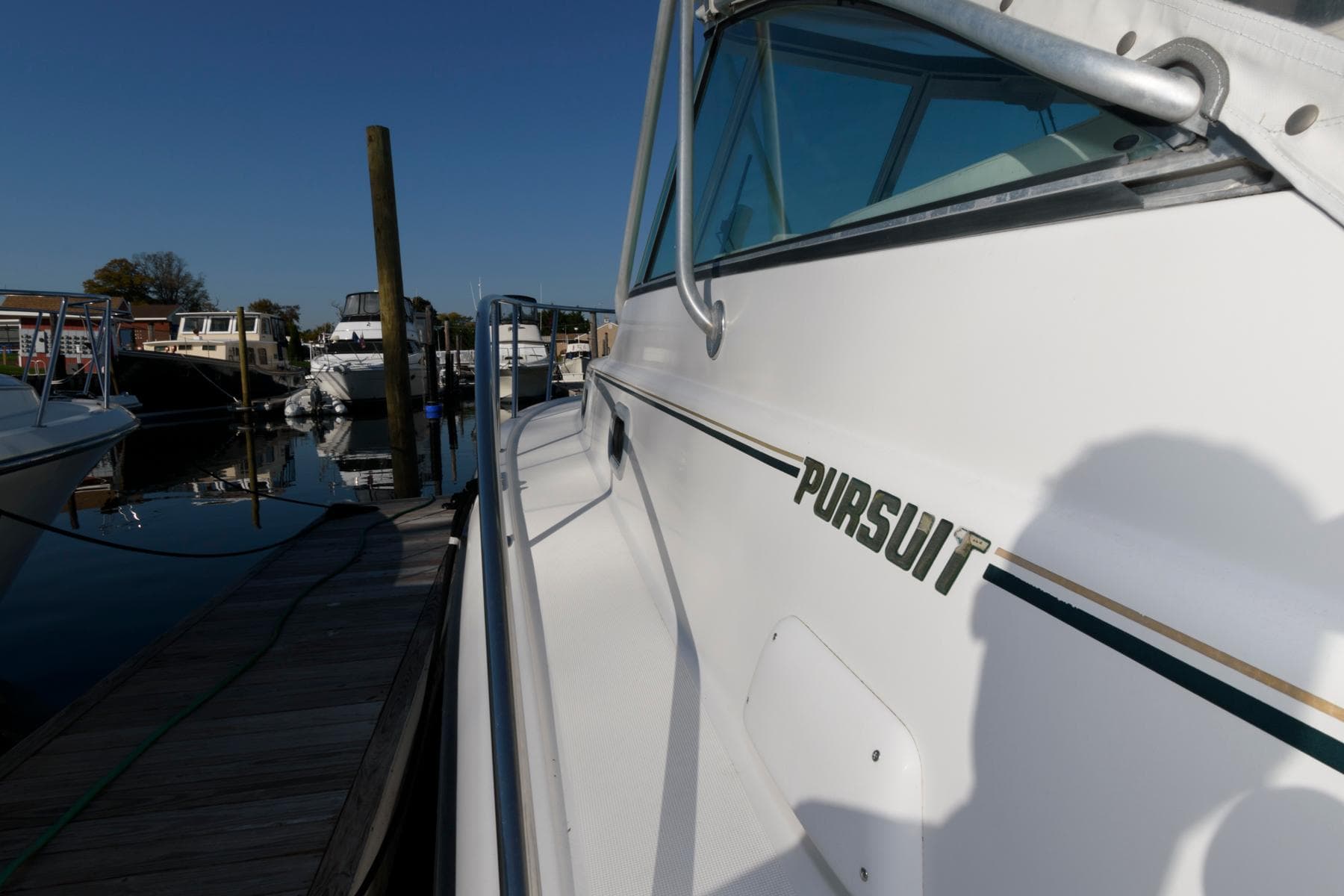 2000 Pursuit 3400 Express boat docked at marina, side view.