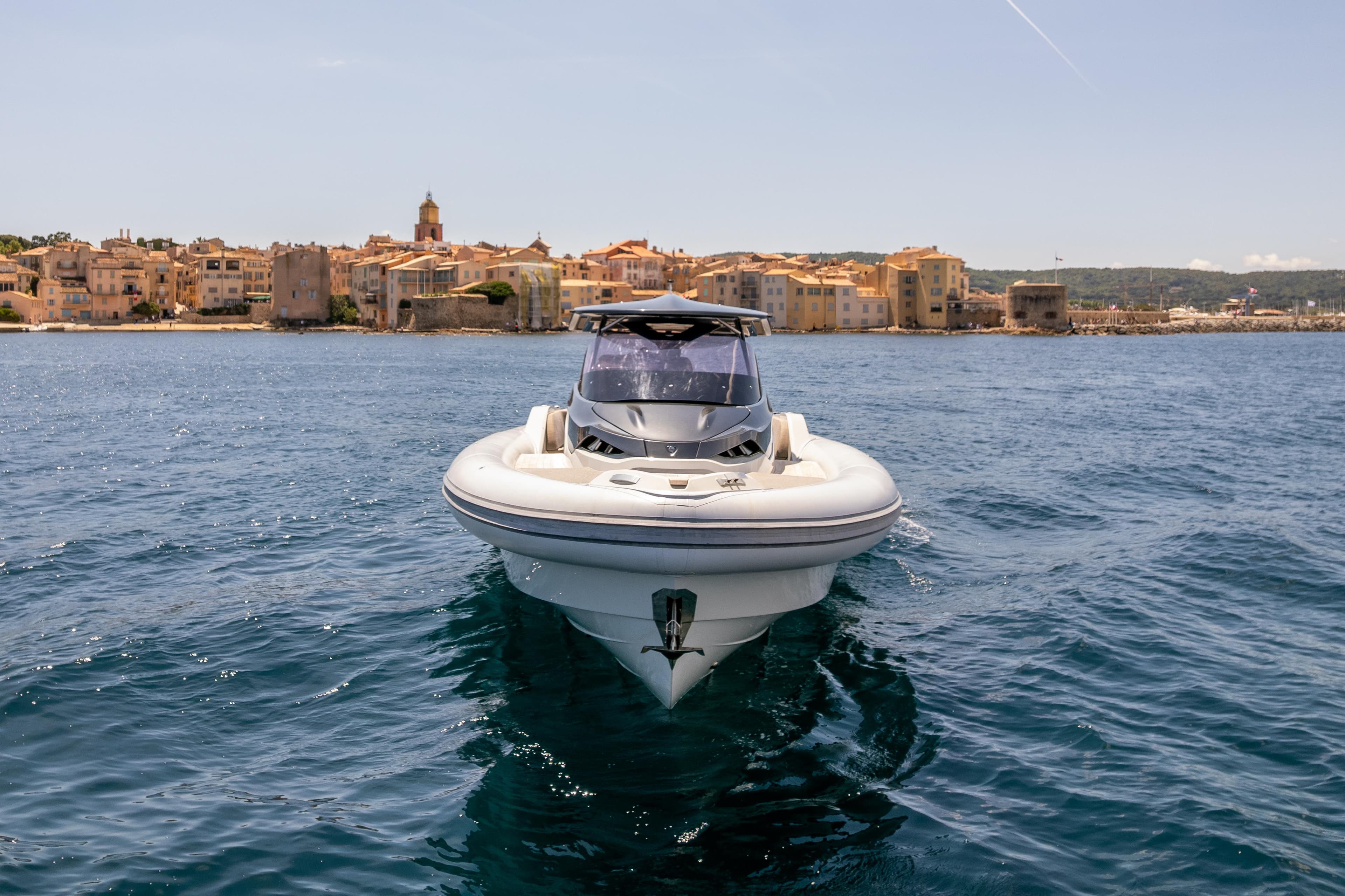 2022 SACS Strider 15 boat on water, with coastal town in background.