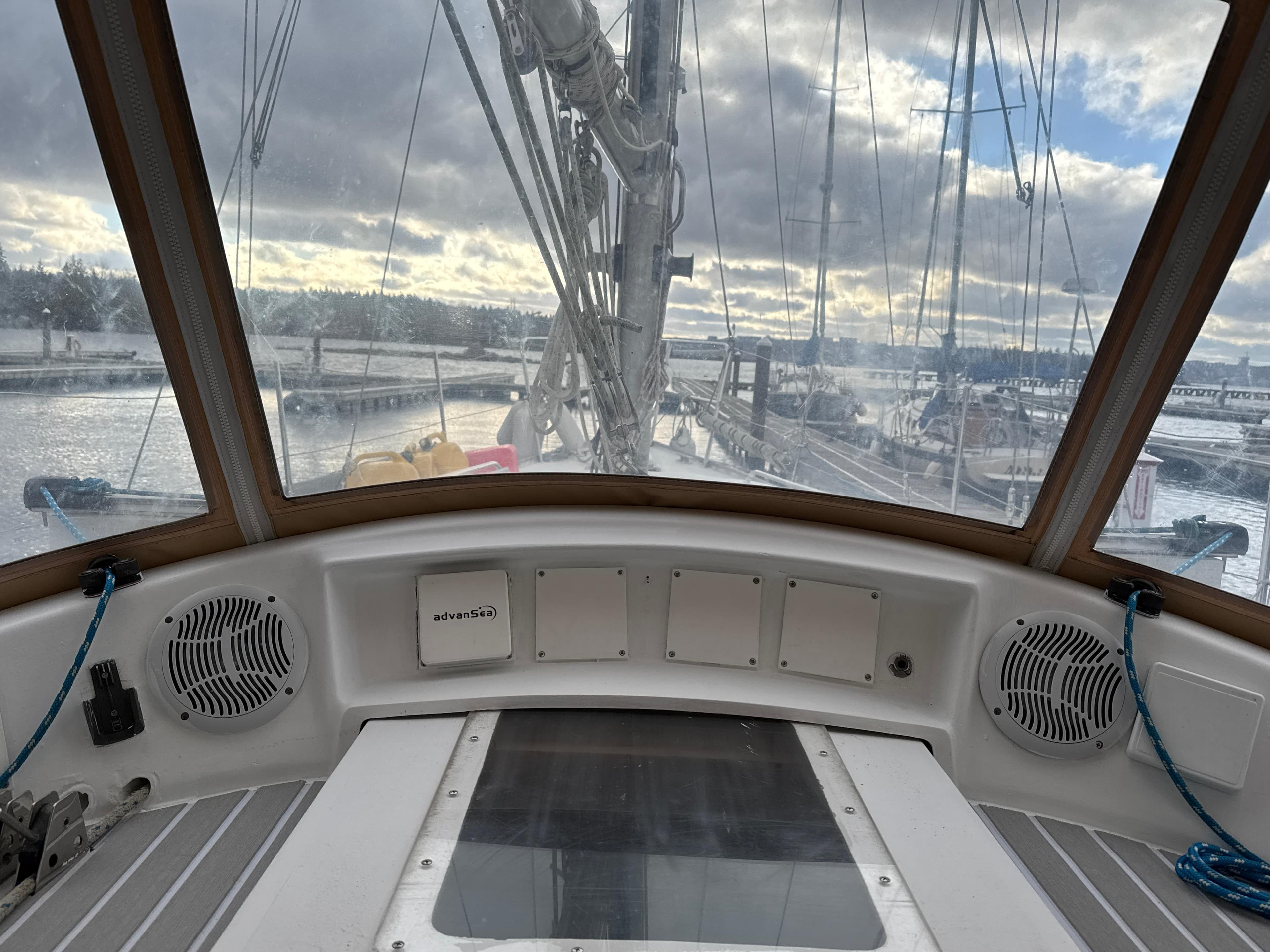 Cockpit view from 1980 Bruce Roberts Mauritius 43 sailboat, overlooking marina and cloudy sky.