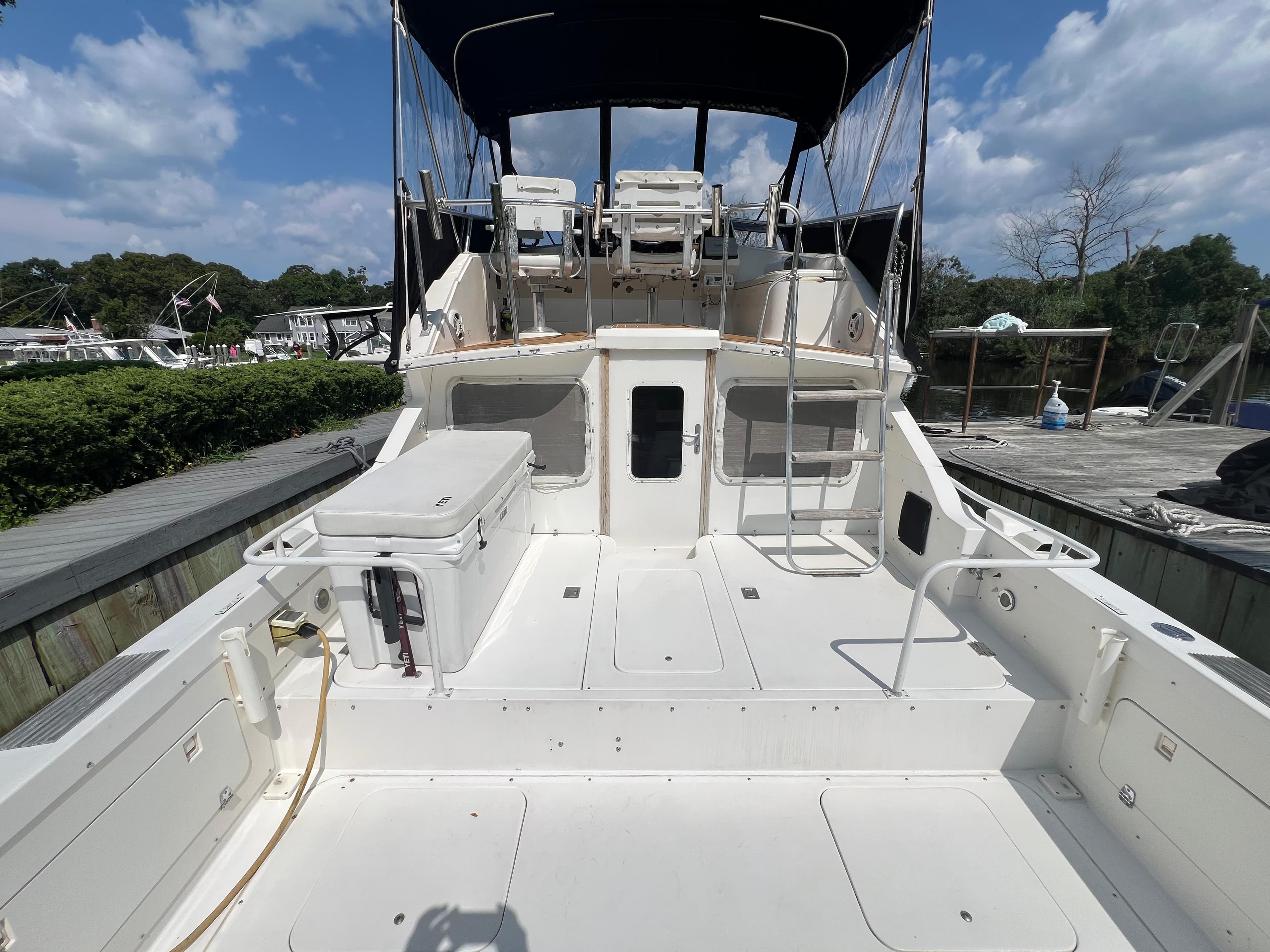 1990 Bertram 28 Flybridge boat with spacious deck and flybridge under a clear sky.
