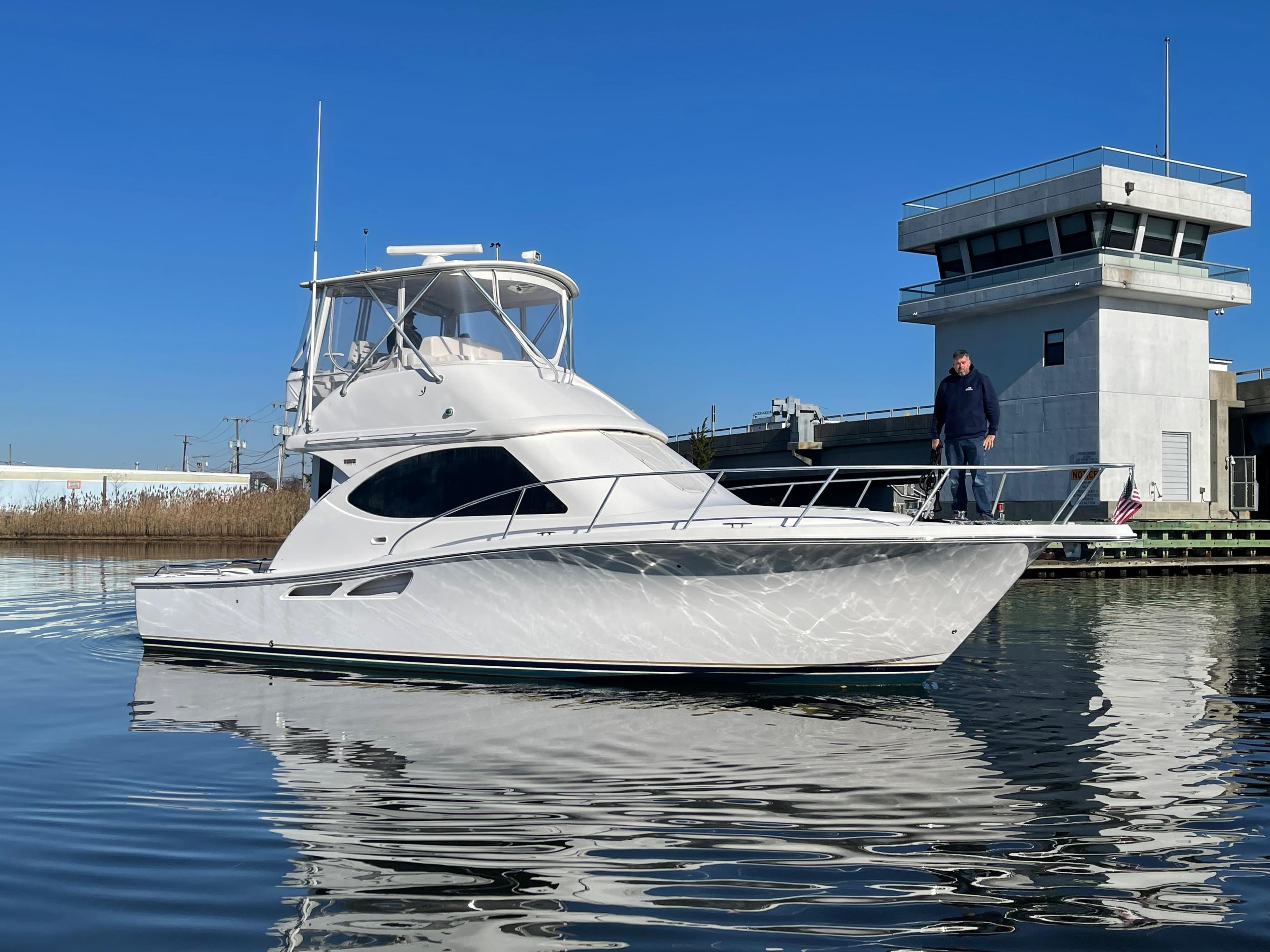 2008 Tiara Yachts 3900 Convertible boat docked near a modern building.
