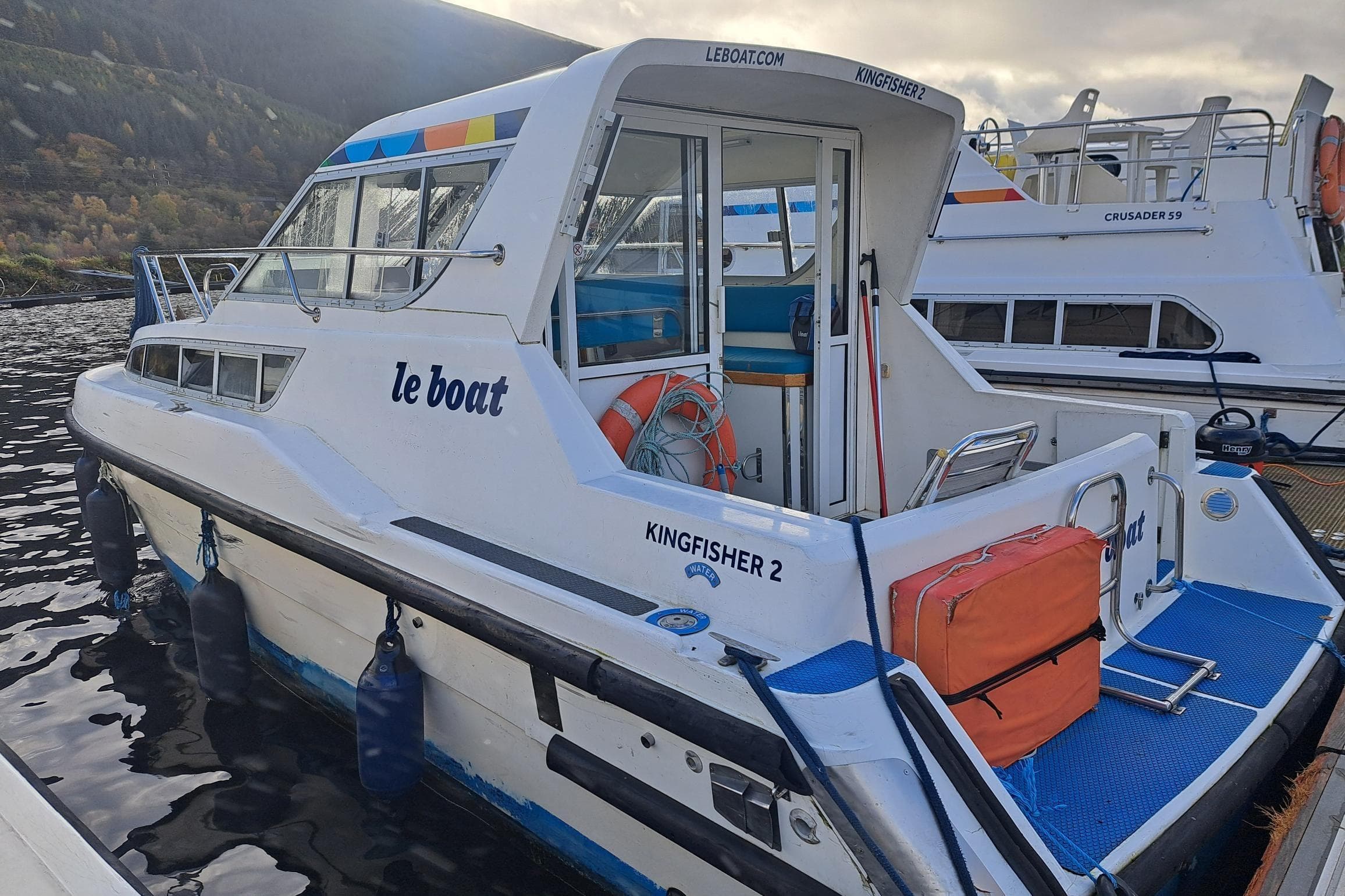 Le Boat Kingfisher 1996 model docked, featuring vibrant colors and safety equipment.