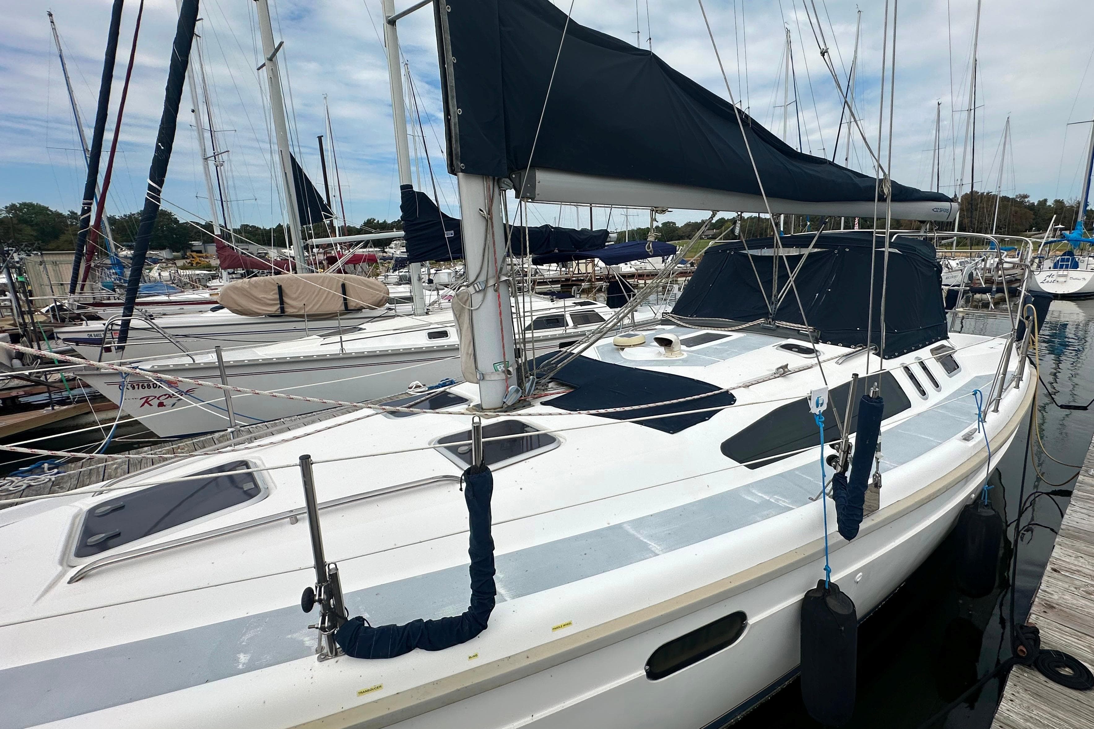 1997 Hunter 376 sailboat docked at a marina, featuring a sleek design and blue covers.