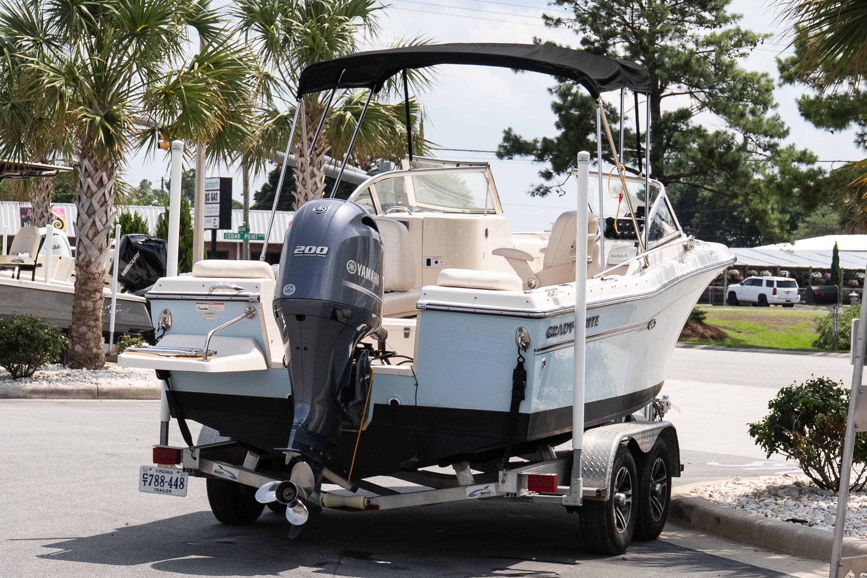 2017 Grady-White Freedom 205 boat on trailer with Yamaha engine, parked near palm trees.