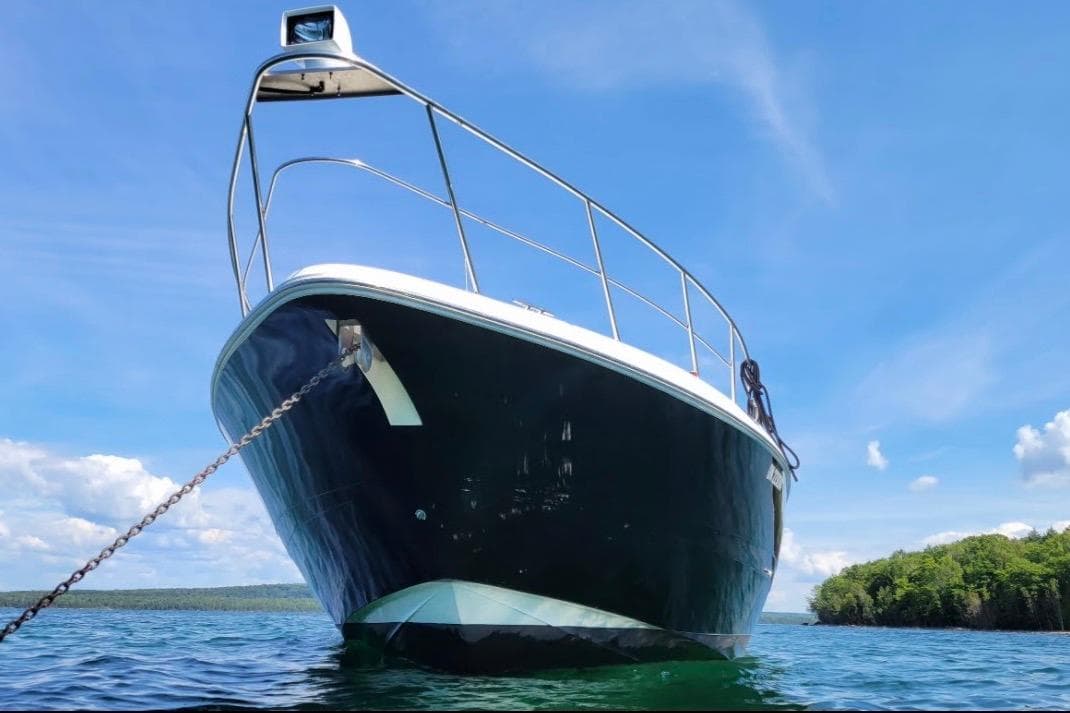 2003 Cruisers 4270 boat anchored on a sunny day with clear blue skies.