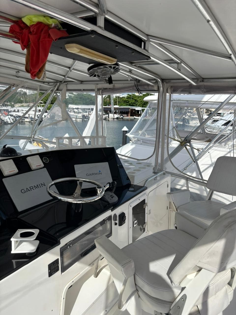 1987 Bertram 50 Convertible yacht helm with Garmin navigation, docked at marina.