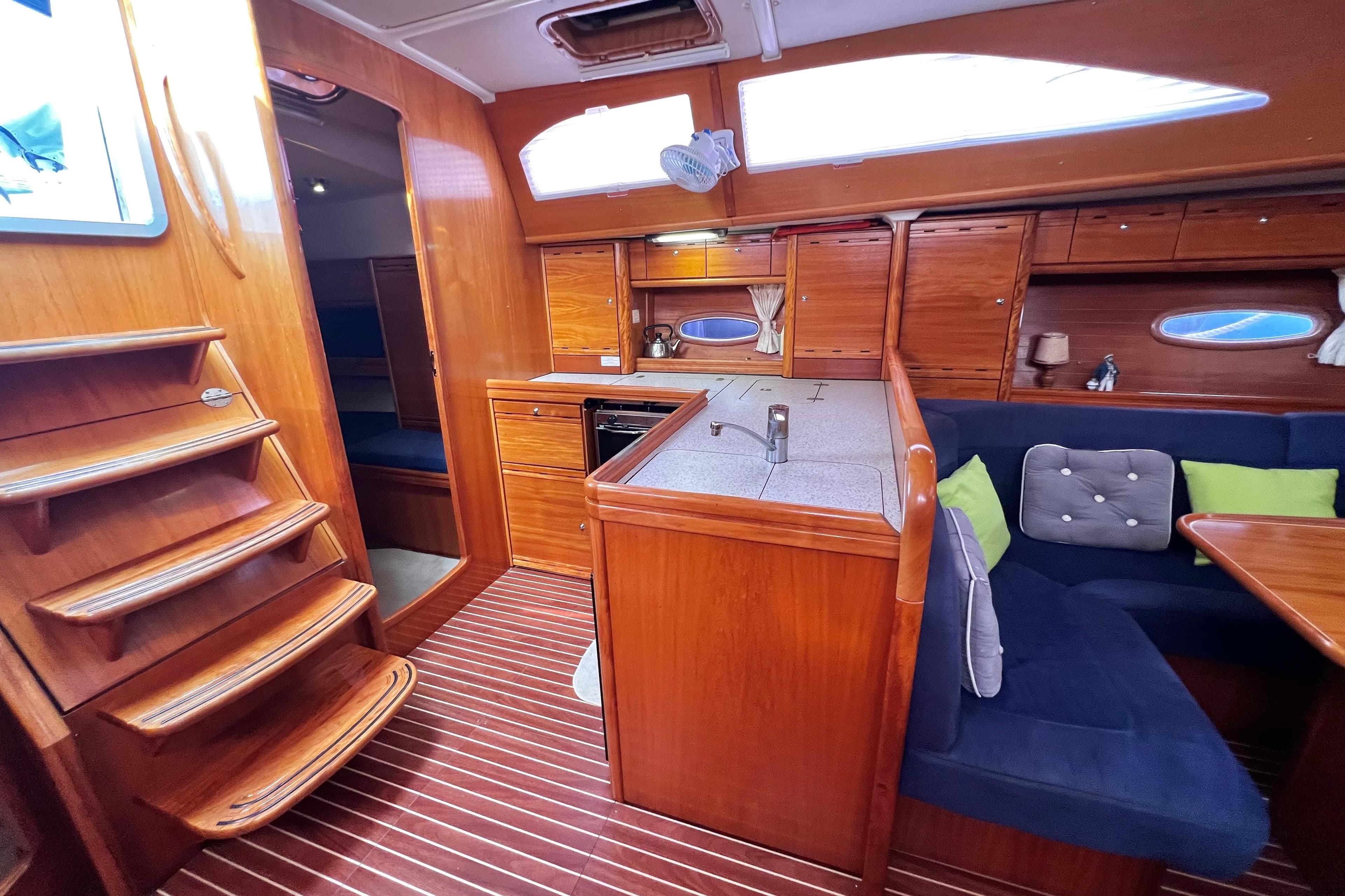Interior of 2007 Bavaria 44 Vision yacht with wooden cabinetry and cozy seating area.