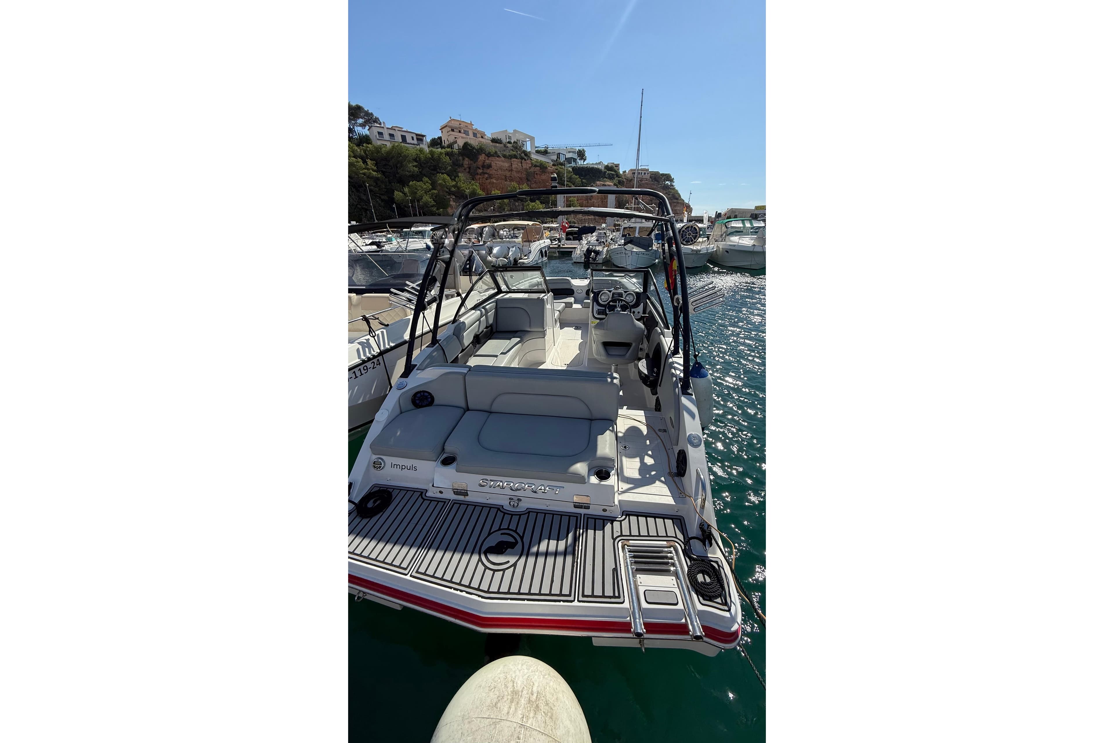 2013 Starcraft Crossover 220 SCX IO boat docked in a sunny marina.