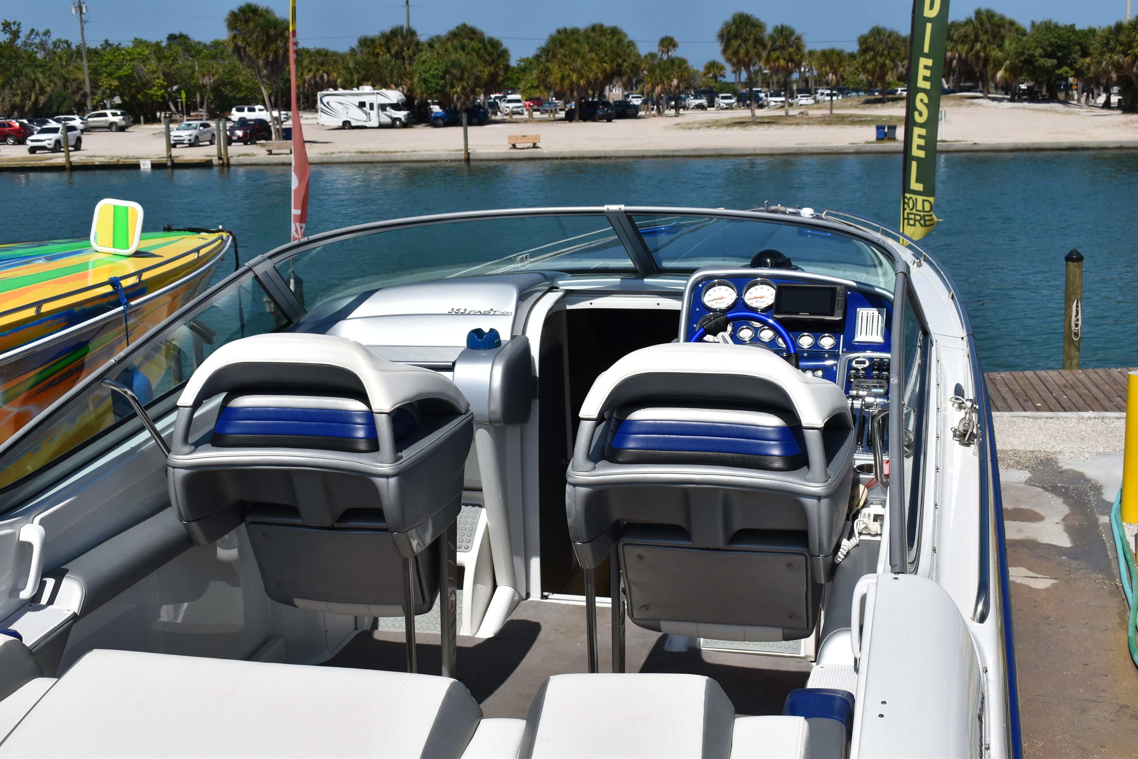 2008 Formula 353 FASTech boat interior with dual seats and dashboard, docked by a scenic waterfront.