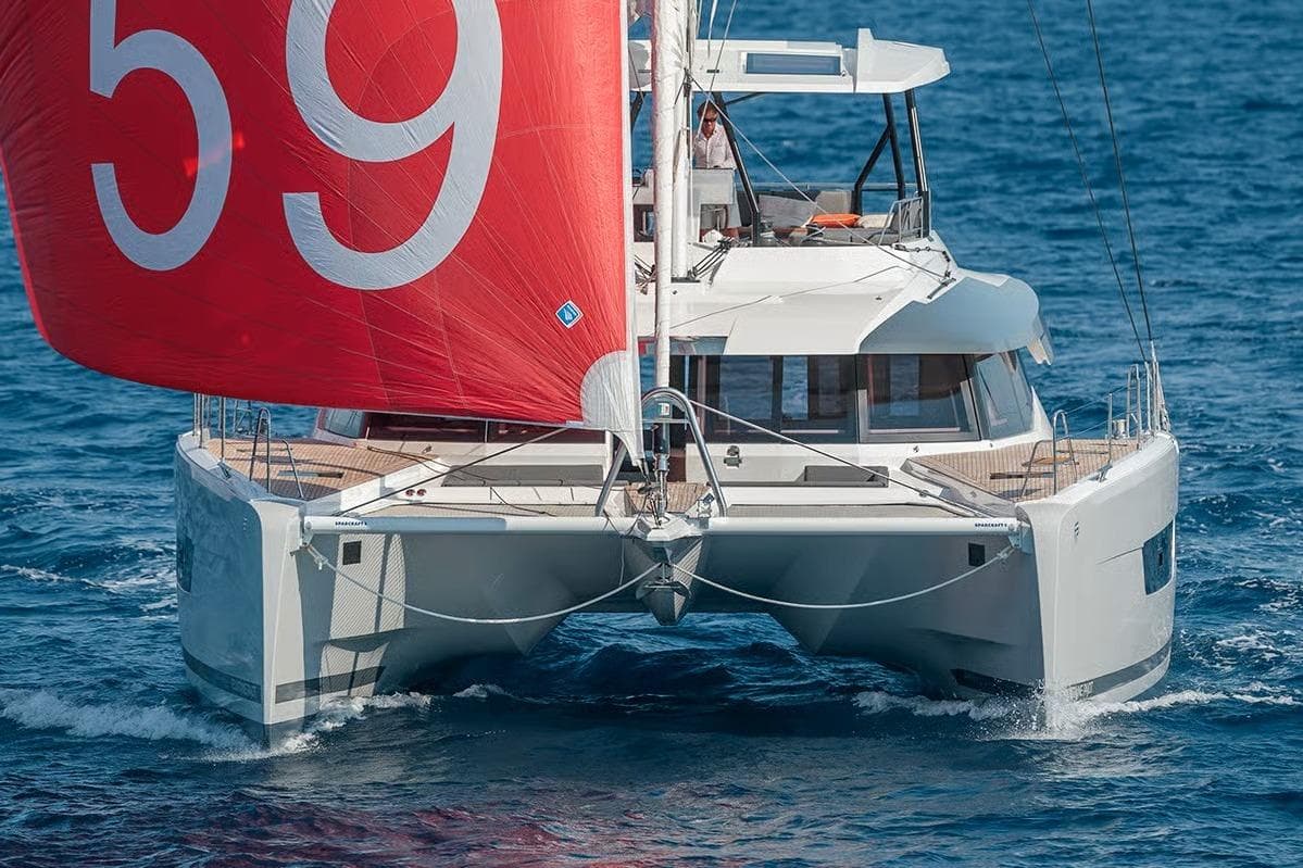 2026 Fountaine Pajot Samana 59 catamaran sailing on open sea with red sail.