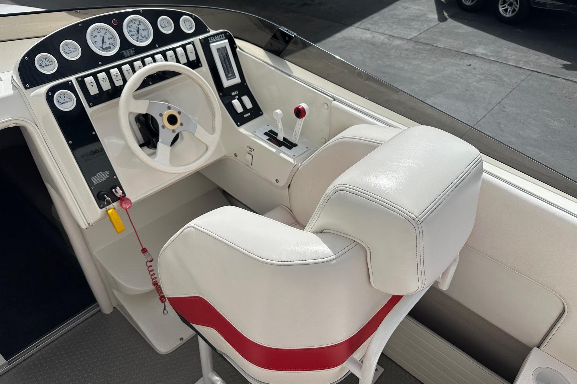 1998 Velocity 26 Thoroughbred boat cockpit with white seats and control panel.
