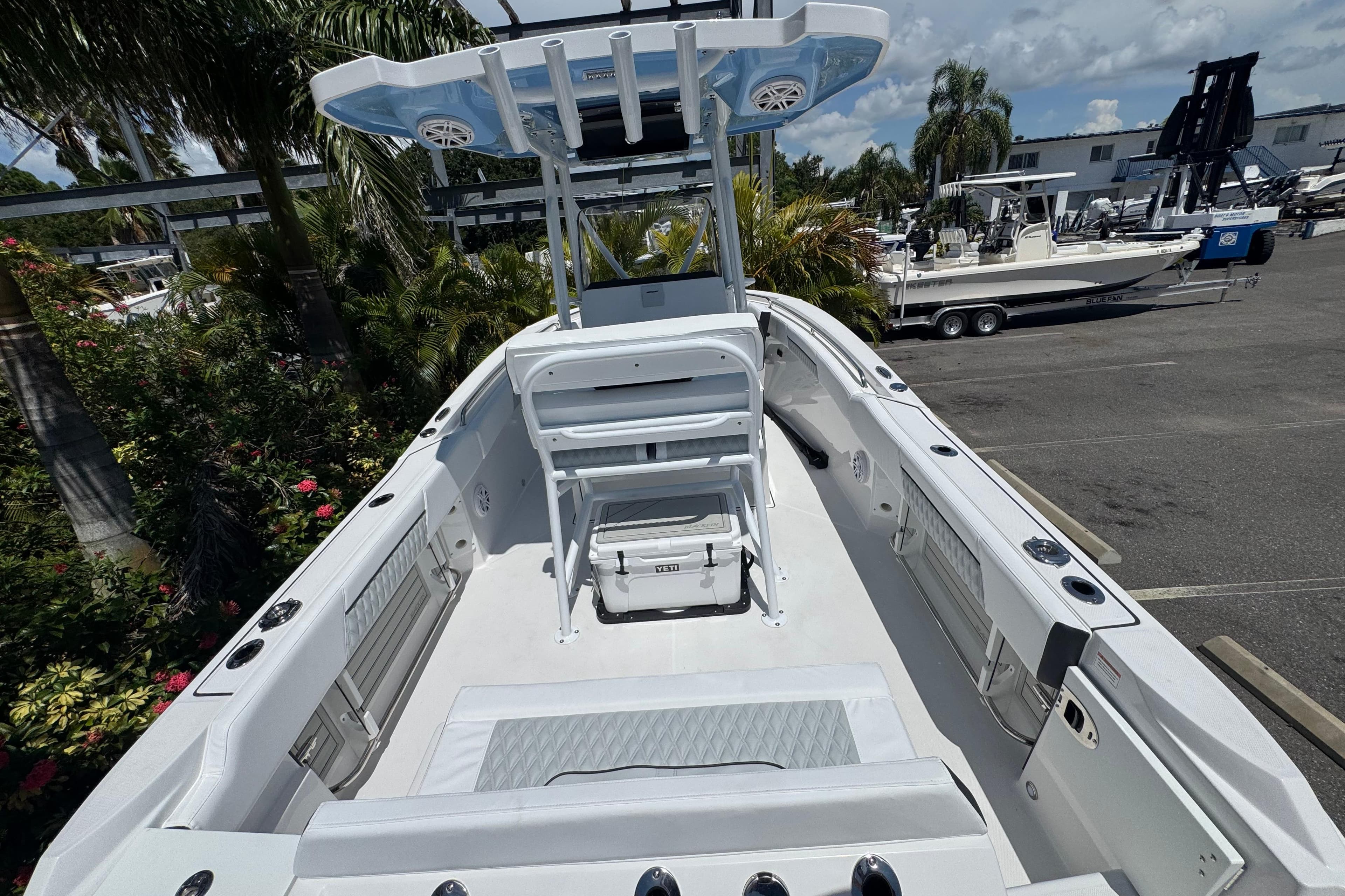 2026 Blackfin 222 CC boat interior with seating and storage, surrounded by lush greenery.
