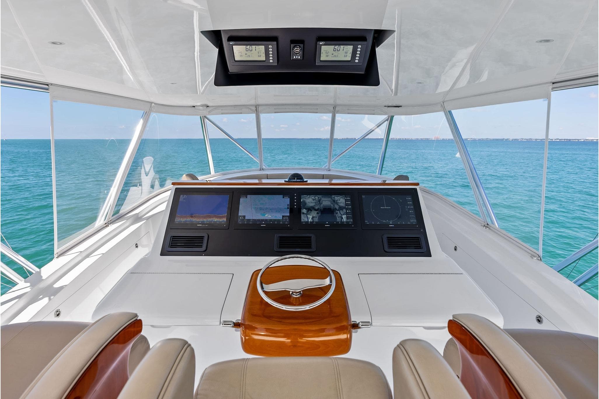 2017 Weaver Custom Sportfish helm with advanced navigation screens, overlooking serene ocean waters.