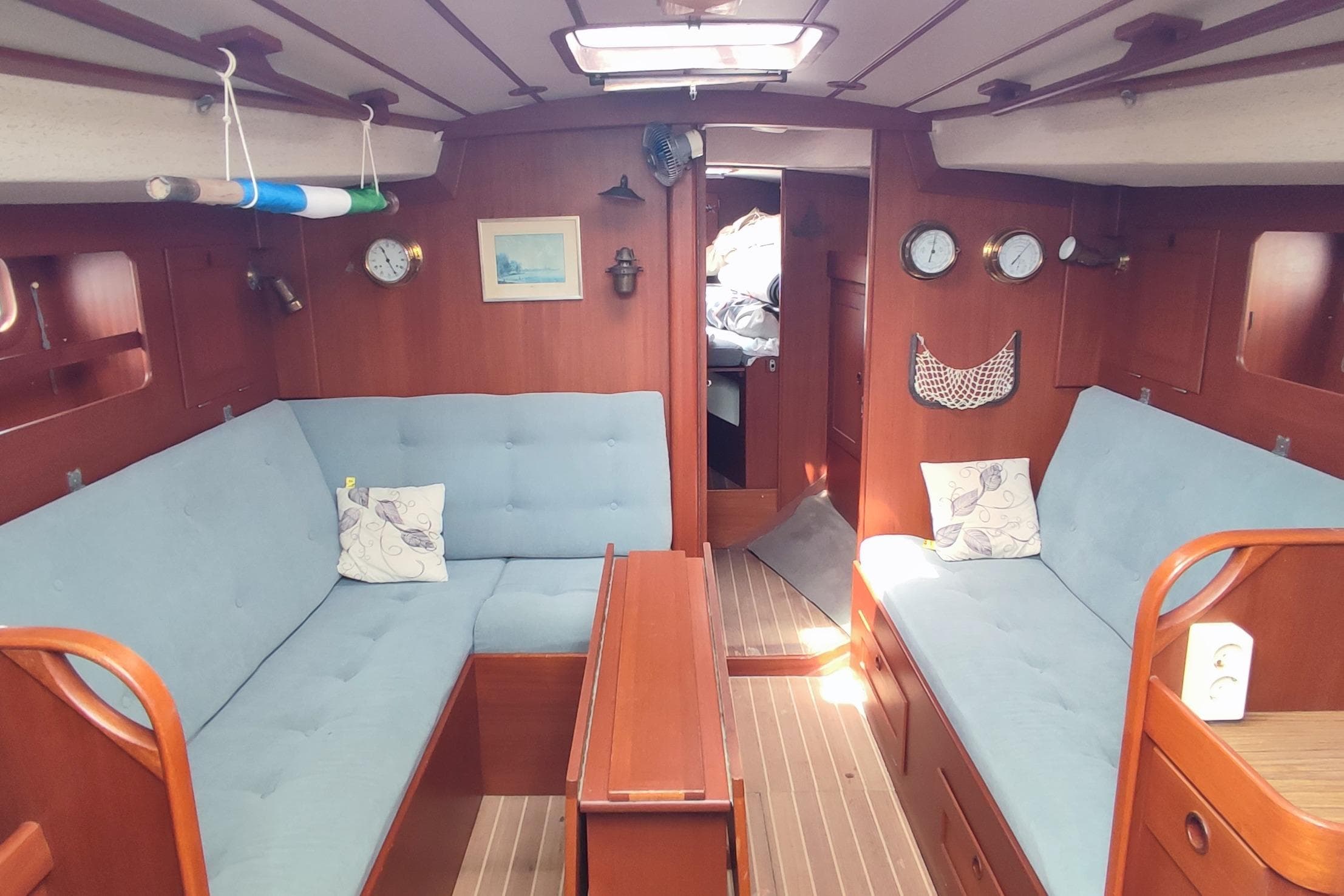 Interior of 1982 Hallberg-Rassy 352 sailboat with blue seating and wooden accents.
