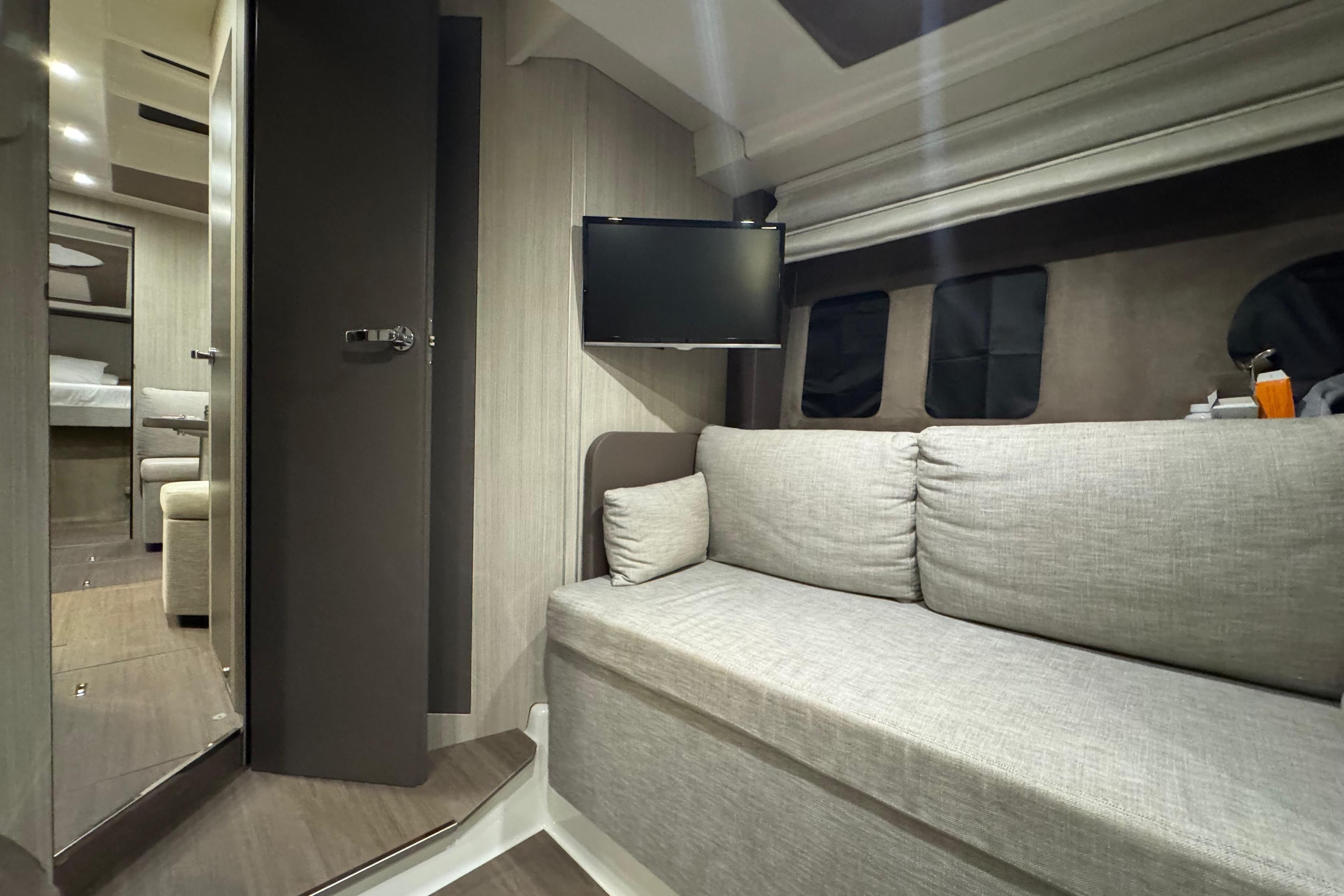 Luxurious interior of 2019 Cranchi M 44 HT yacht with sofa and TV.