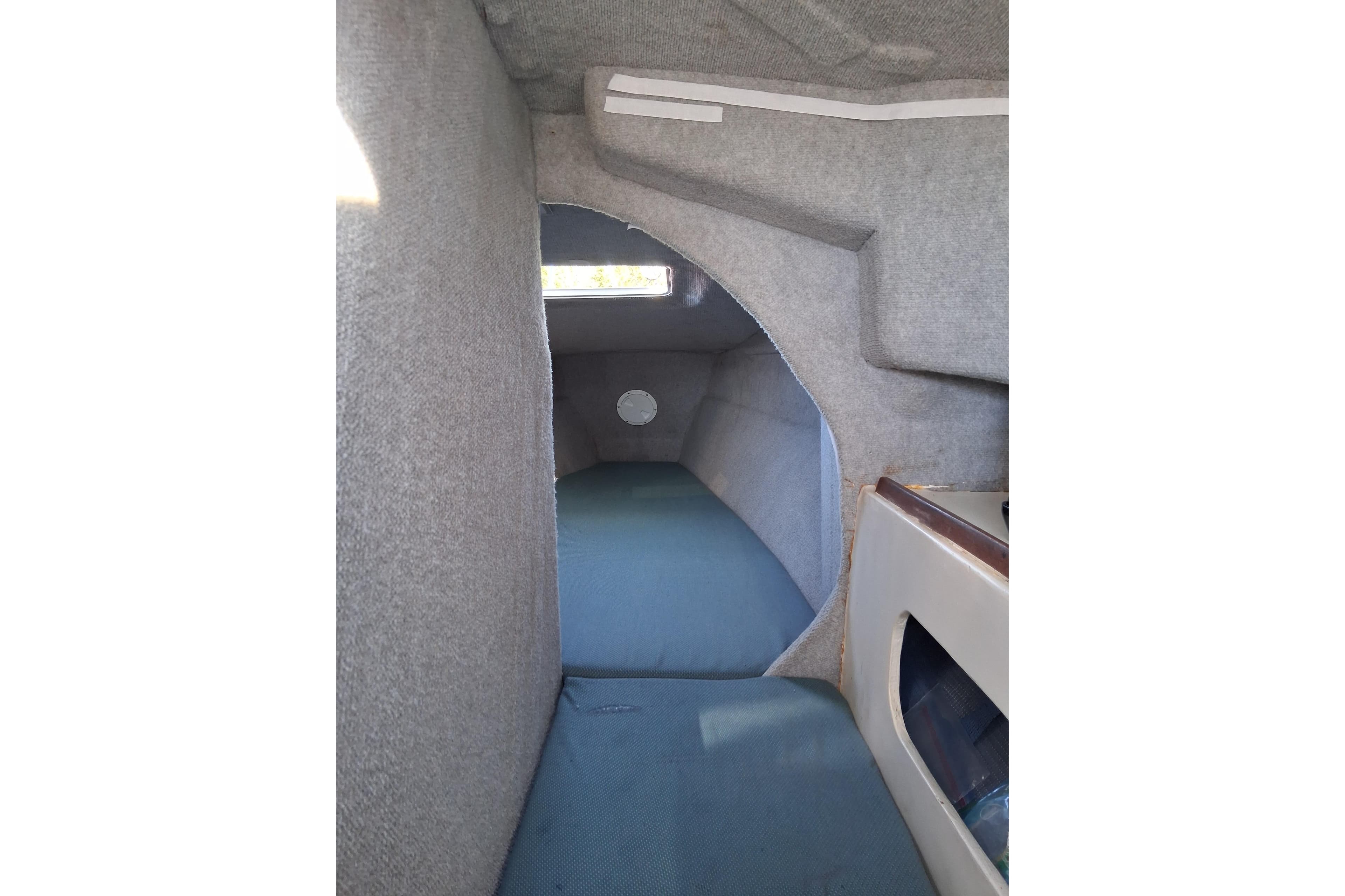 Interior cabin of a 2000 Farrier 31 sailboat, featuring gray upholstery and compact design.