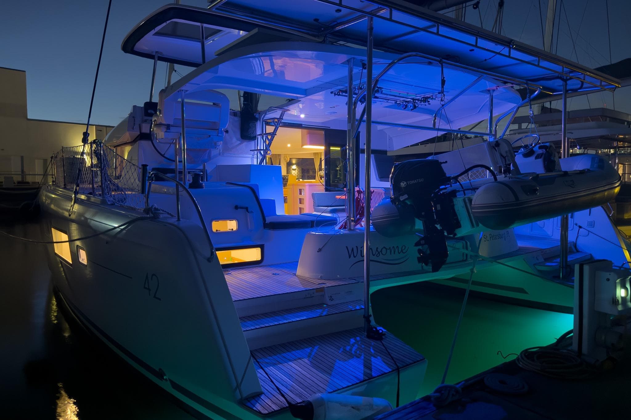 2018 Lagoon 42 catamaran illuminated at night, docked with blue ambient lighting.