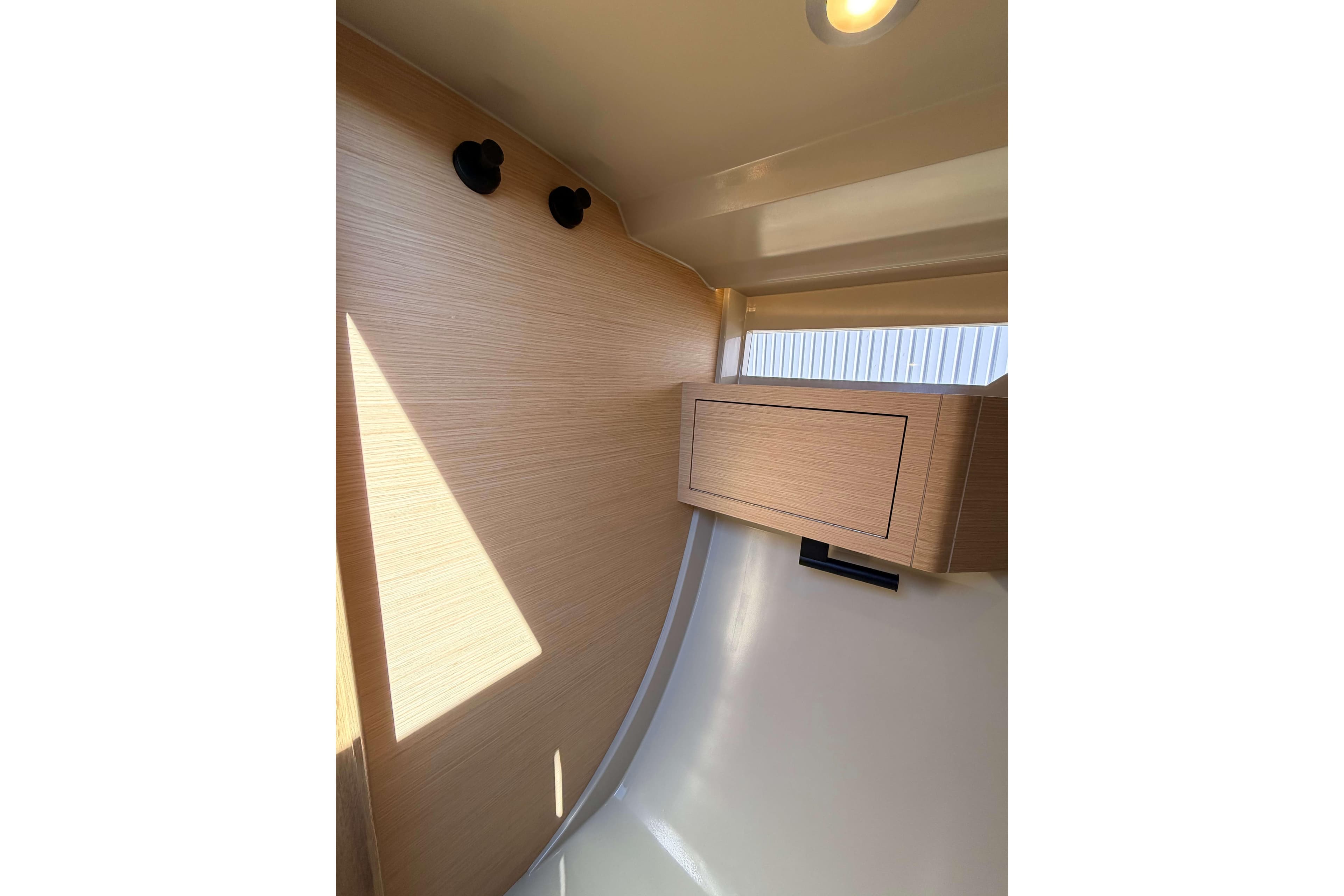 Interior of 2022 Saffier SE 33 Life sailboat, featuring sleek wooden cabinetry and modern lighting.