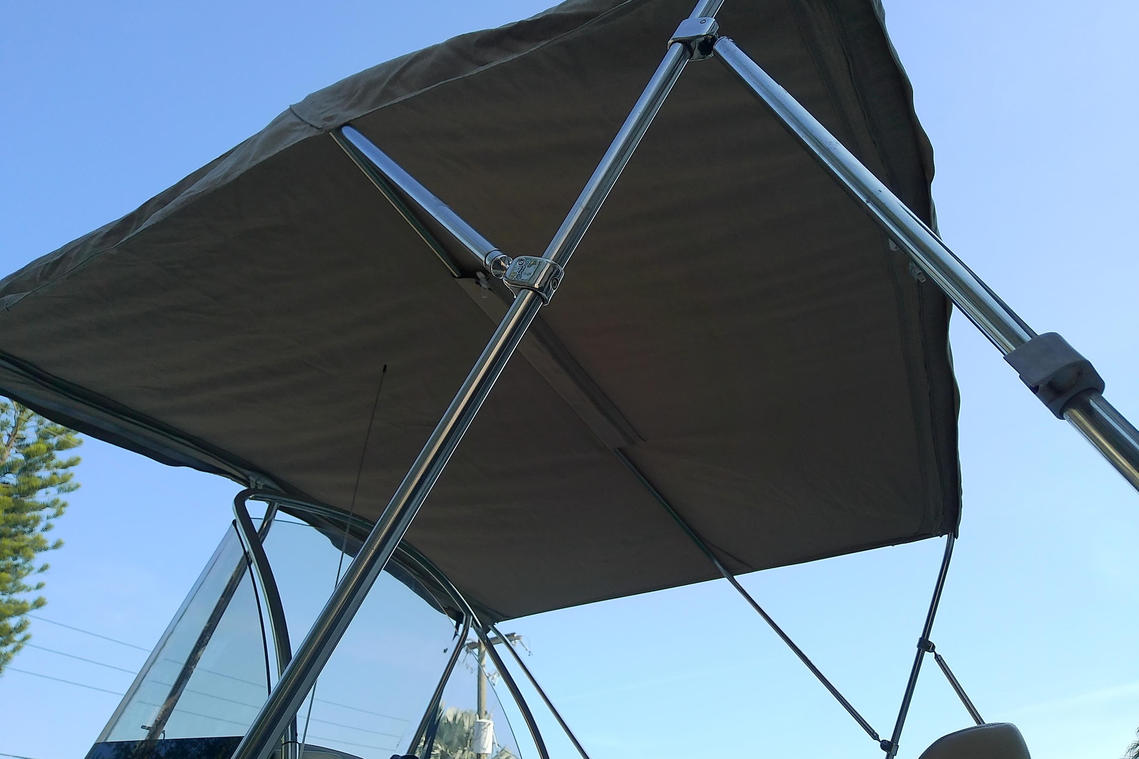 2018 Scout 251 XSS boat with canopy against clear blue sky.